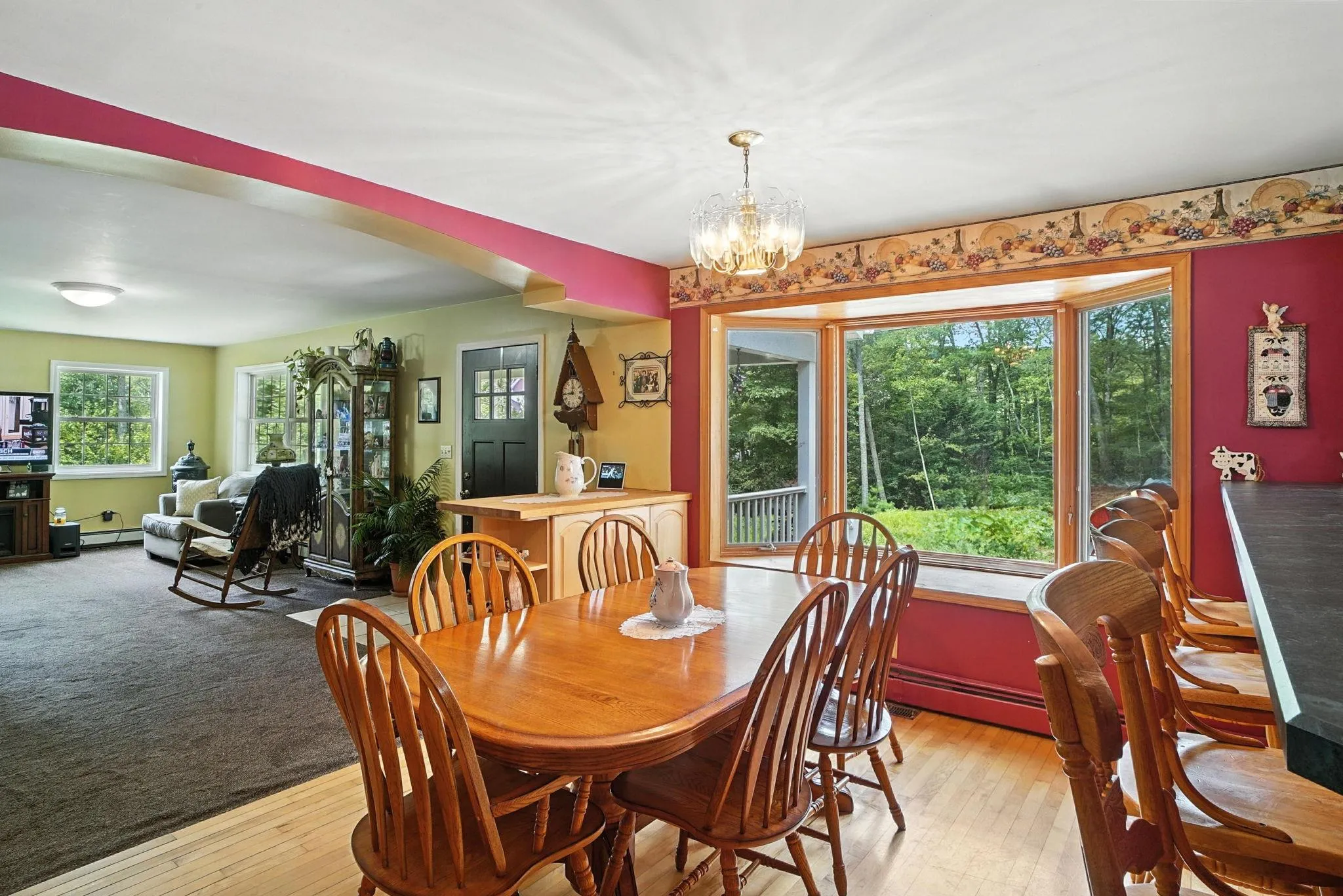 Dining area with a chandelier, arched walkways, light wood finished floors, and a baseboard radiator Dining area with a chandelier, arched walkways, light wood finished floors, and a baseboard radiator
