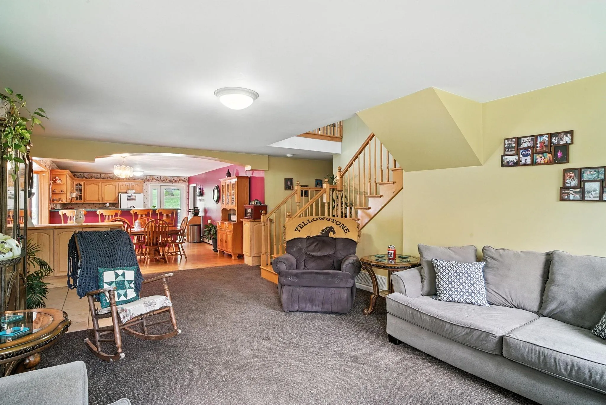Living area with arched walkways, stairs, a chandelier, and light colored carpet Living area with arched walkways, stairs, a chandelier, and light colored carpet