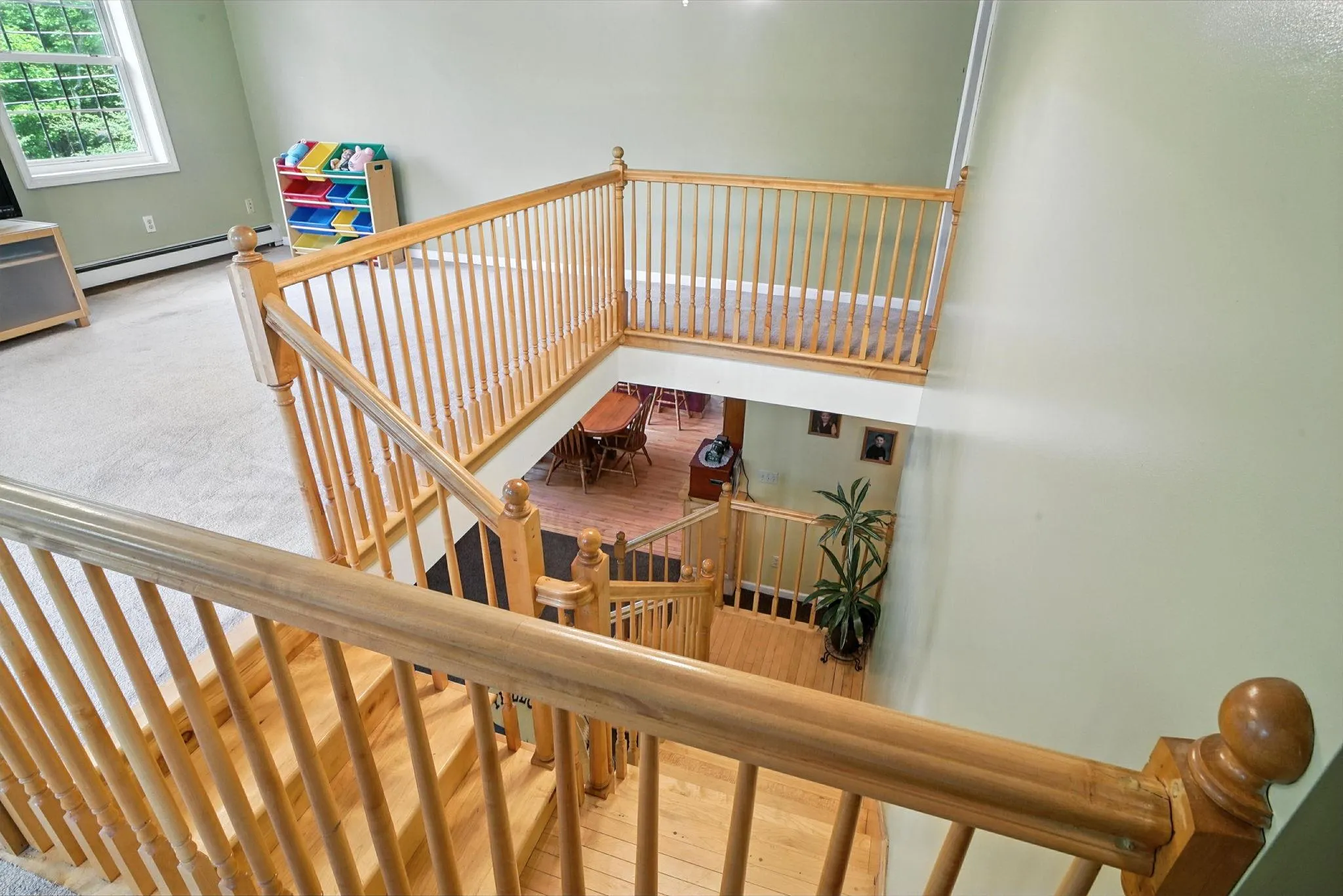 Stairway featuring a baseboard radiator and wood finished floors Stairway featuring a baseboard radiator and wood finished floors