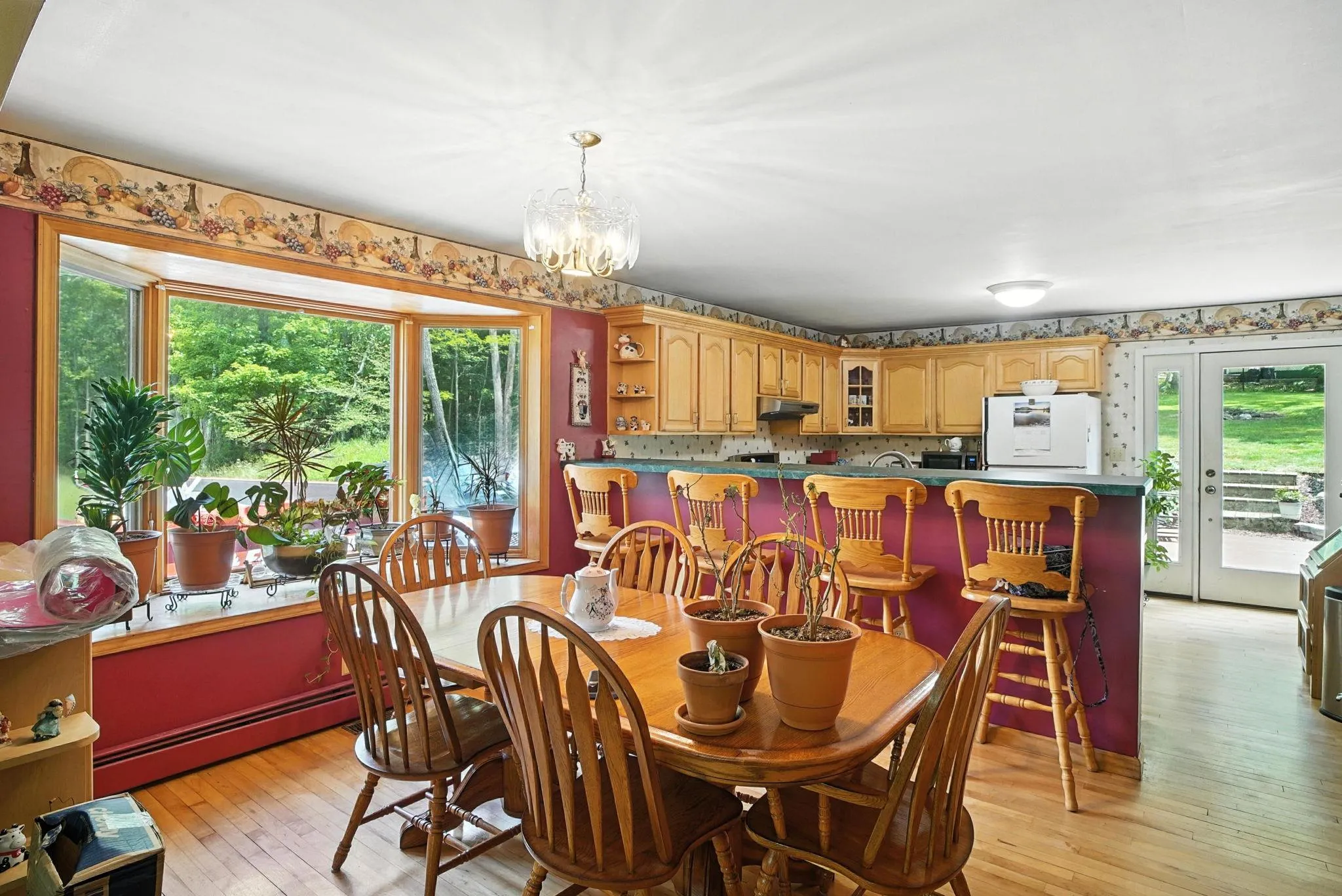 Dining space featuring a chandelier, light wood-style flooring, and a baseboard radiator Dining space featuring a chandelier, light wood-style flooring, and a baseboard radiator
