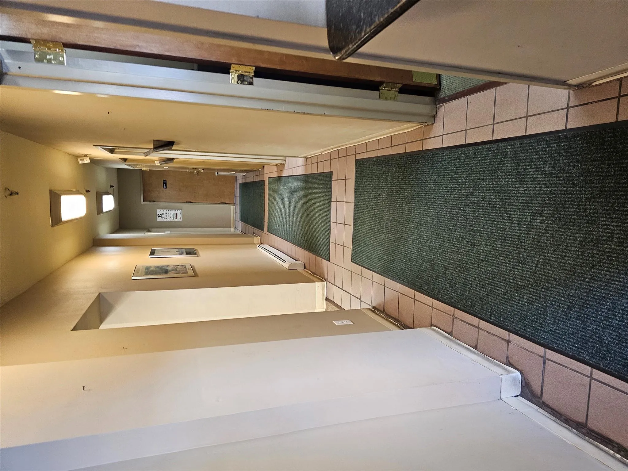 Corridor with light tile patterned floors and a baseboard heating unit Corridor with light tile patterned floors and a baseboard heating unit