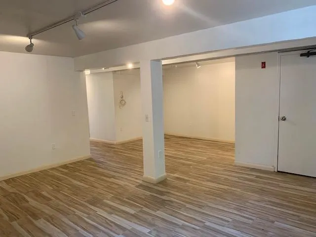 Finished below grade area with track lighting and wood finished floors Finished below grade area with track lighting and wood finished floors