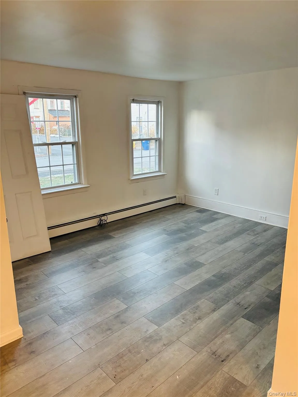 Spare room featuring baseboard heating and light wood finished floors Spare room featuring baseboard heating and light wood finished floors