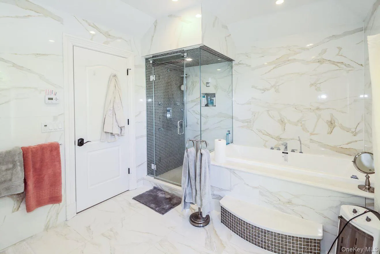 Full bathroom with a garden tub, a marble finish shower, and marble finish floors Full bathroom with a garden tub, a marble finish shower, and marble finish floors
