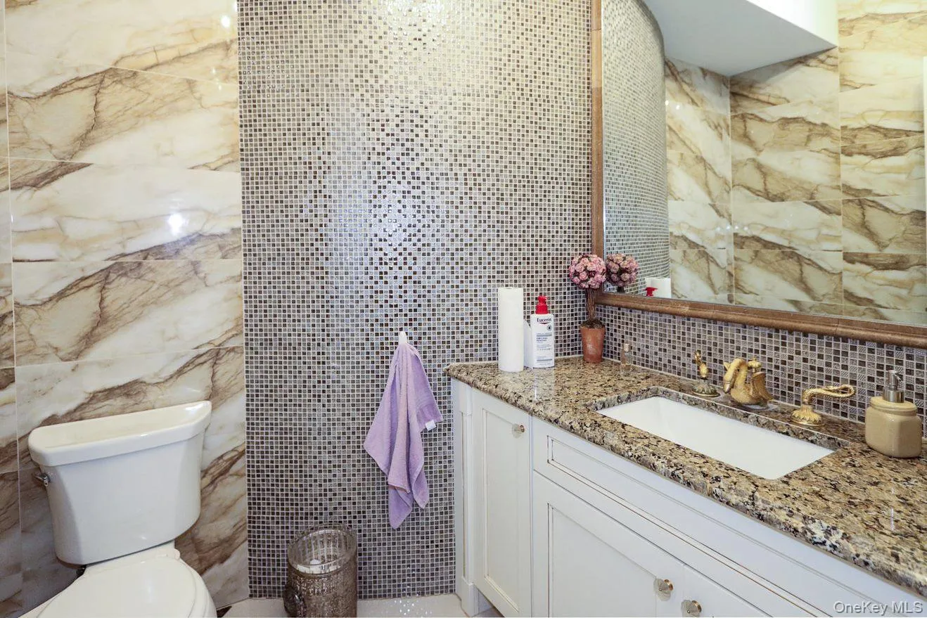 Bathroom with tile walls, vanity, and tasteful backsplash Bathroom with tile walls, vanity, and tasteful backsplash