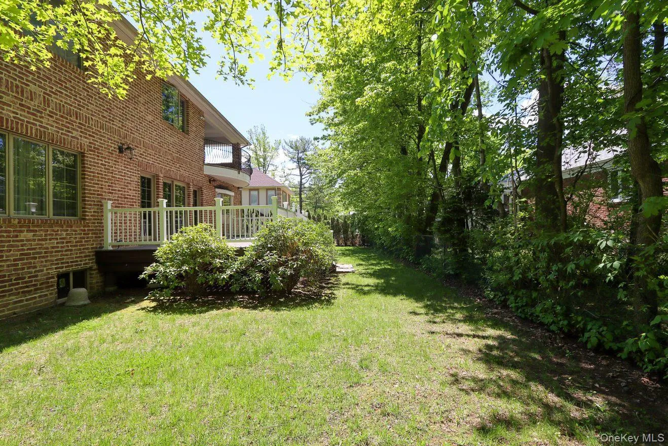 View of grassy yard featuring a wooden deck View of grassy yard featuring a wooden deck