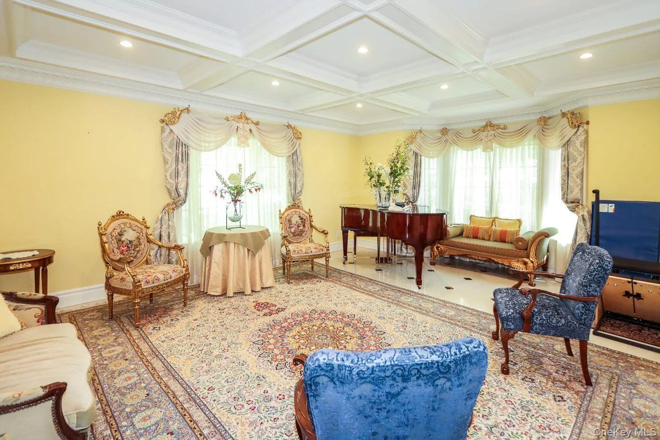 Living area featuring healthy amount of natural light, beamed ceiling, ornamental molding, coffered ceiling, and recessed lighting Living area featuring healthy amount of natural light, beamed ceiling, ornamental molding, coffered ceiling, and recessed lighting