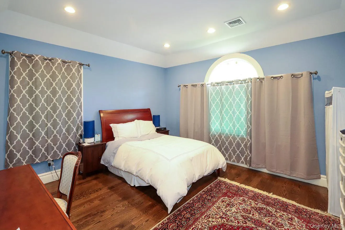 Bedroom with wood finished floors, recessed lighting, and a baseboard radiator Bedroom with wood finished floors, recessed lighting, and a baseboard radiator