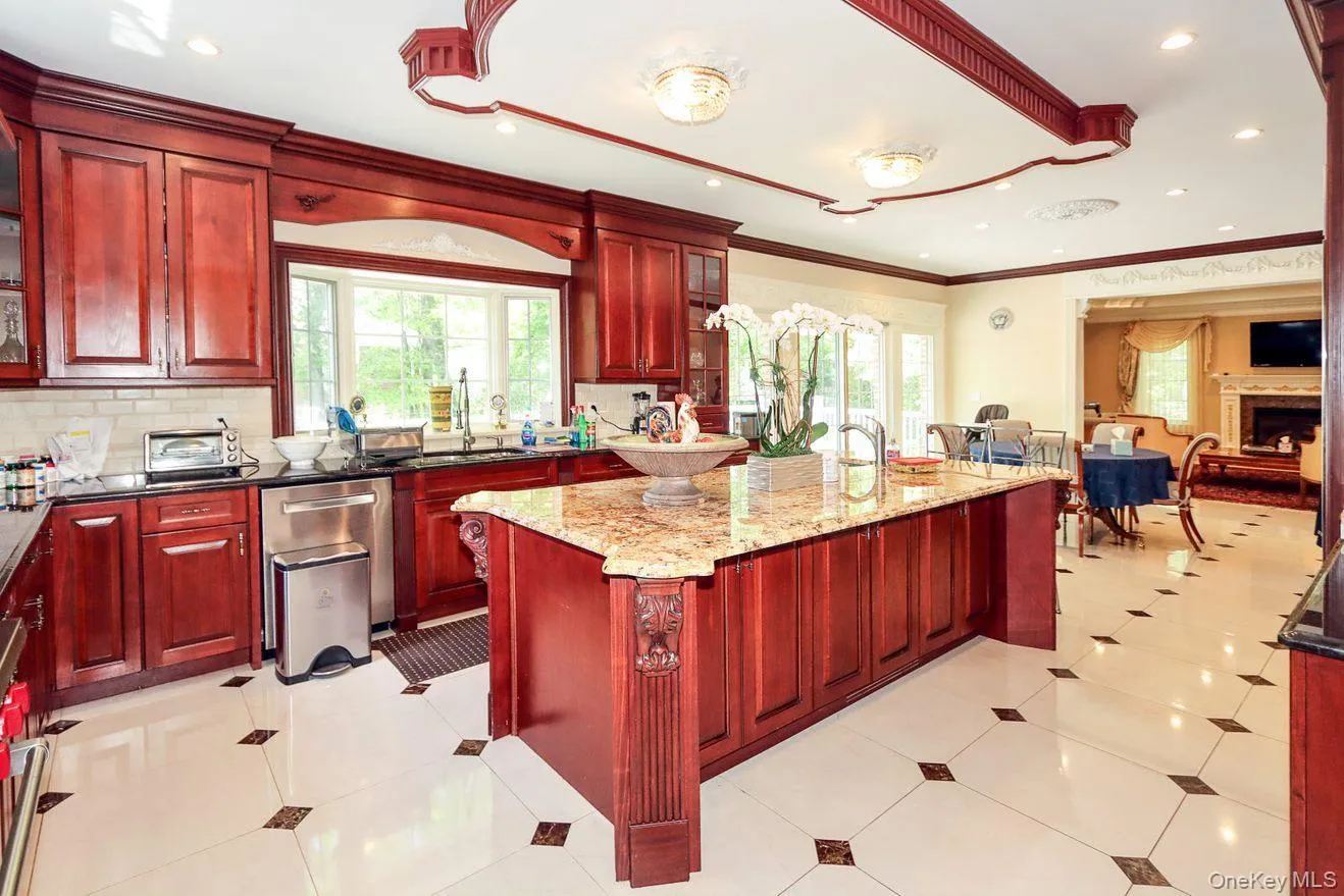 Kitchen with dark brown cabinets, healthy amount of natural light, recessed lighting, light stone countertops, and open floor plan Kitchen with dark brown cabinets, healthy amount of natural light, recessed lighting, light stone countertops, and open floor plan