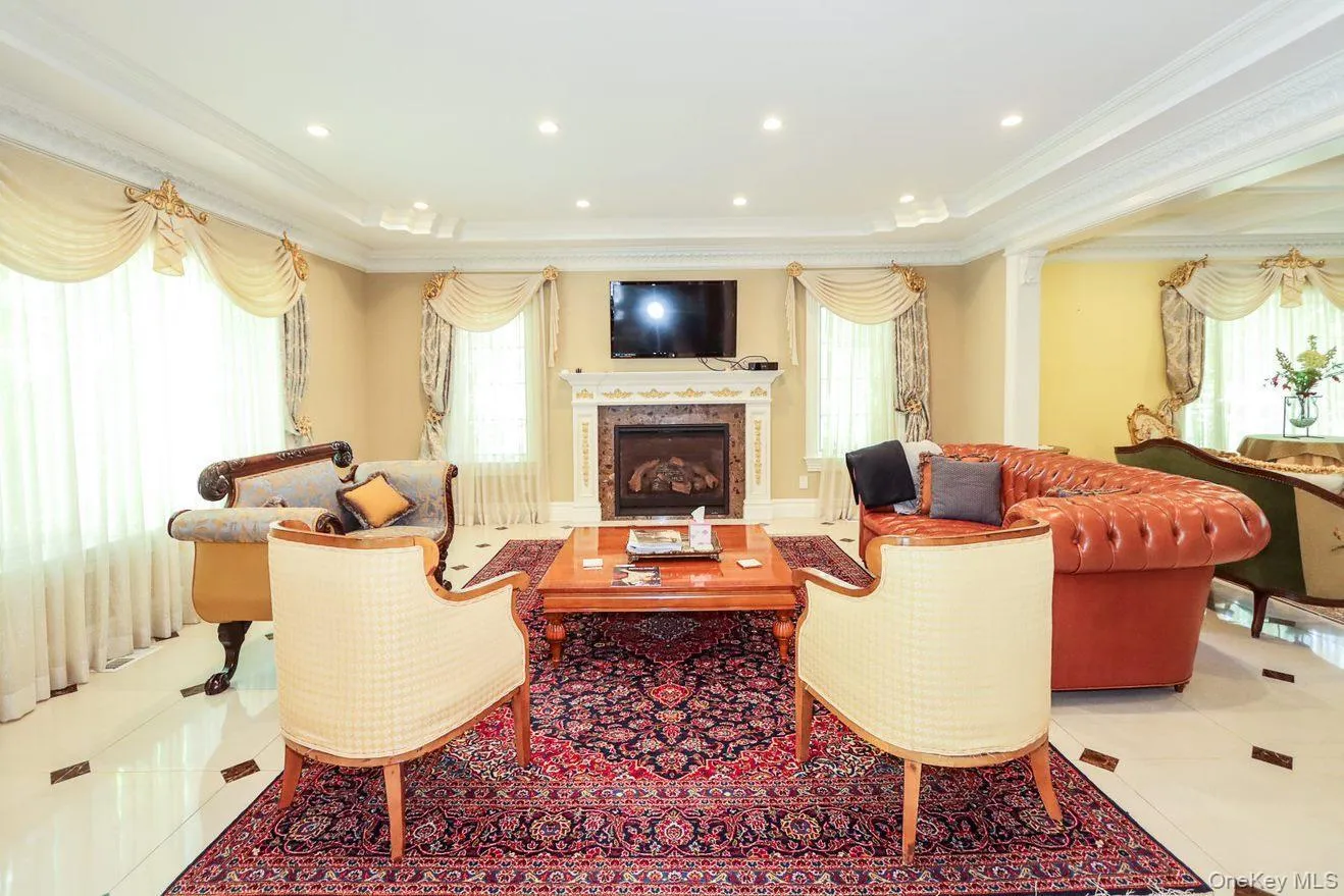 Living area featuring crown molding, plenty of natural light, a fireplace, and a tray ceiling Living area featuring crown molding, plenty of natural light, a fireplace, and a tray ceiling