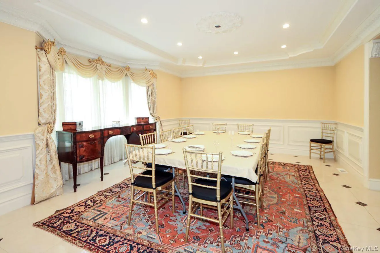 Dining space with a decorative wall, a tray ceiling, wainscoting, ornamental molding, and recessed lighting Dining space with a decorative wall, a tray ceiling, wainscoting, ornamental molding, and recessed lighting