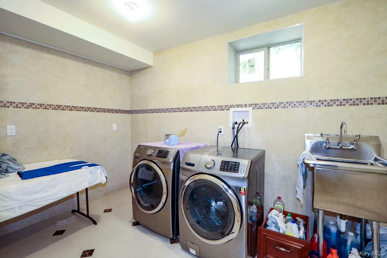 Washroom featuring washer and dryer and tile walls Washroom featuring washer and dryer and tile walls