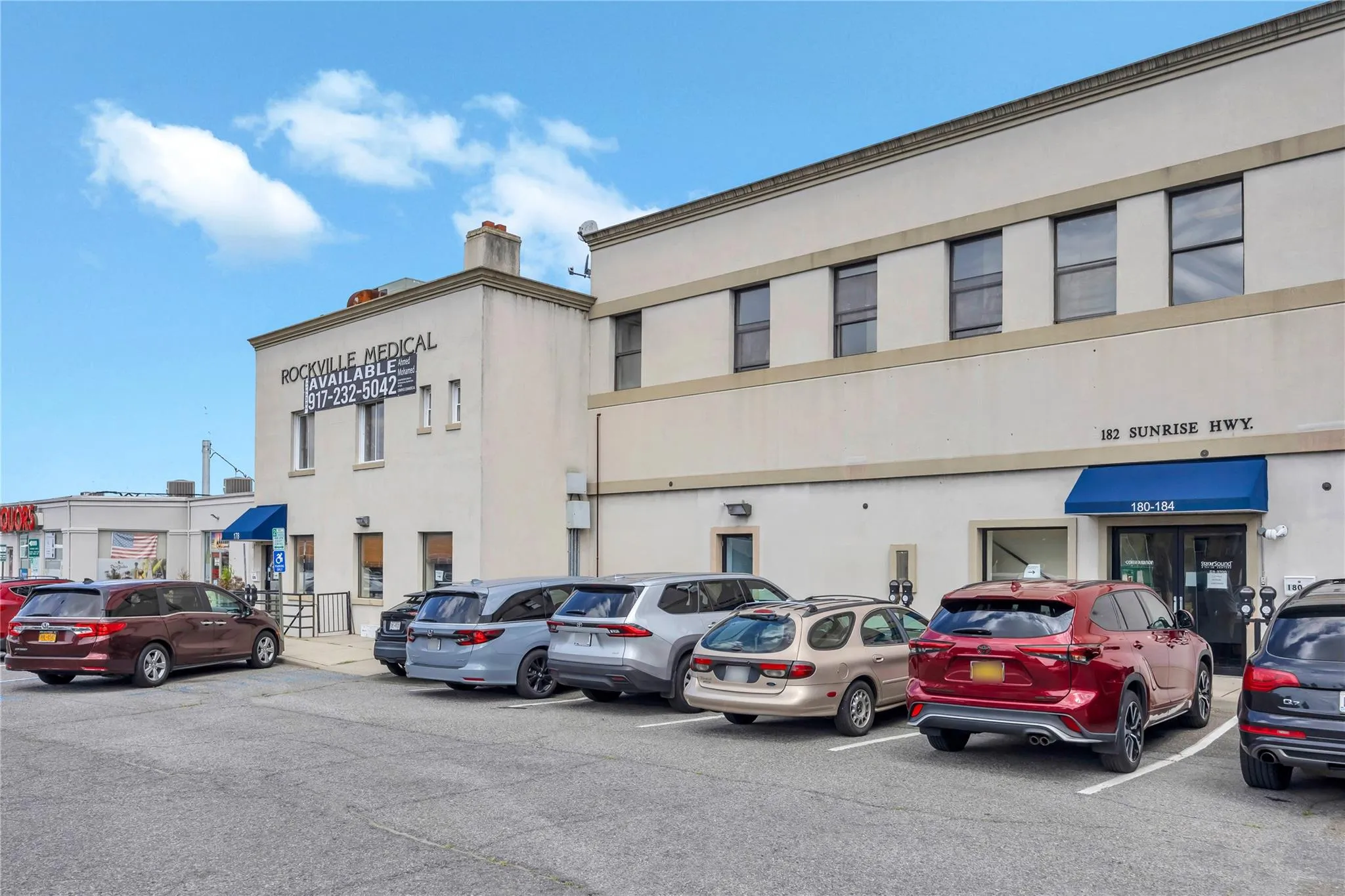 View of commercial property with uncovered parking View of commercial property with uncovered parking
