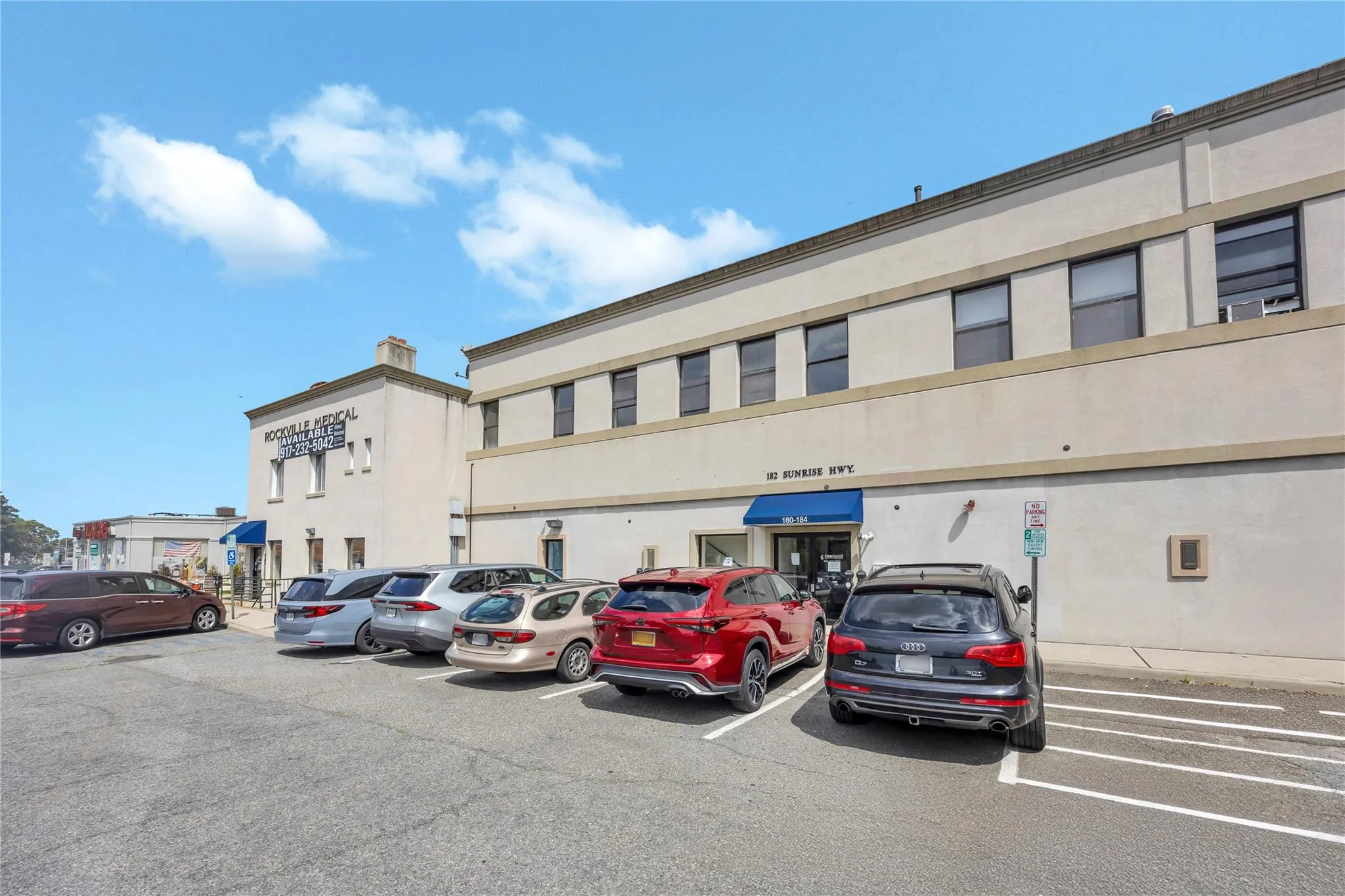 View of commercial property with uncovered parking View of commercial property with uncovered parking