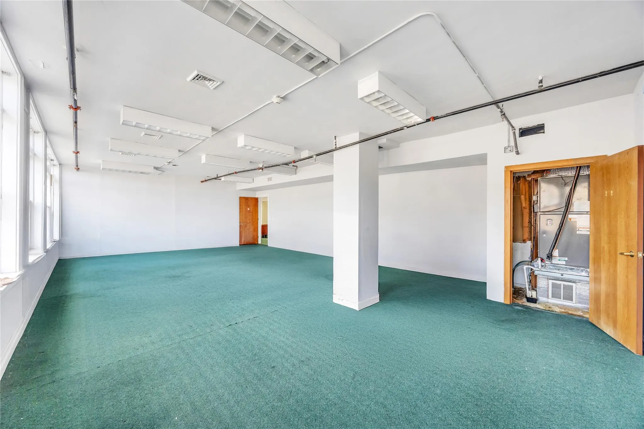 Below grade area with carpet and heating unit Below grade area with carpet and heating unit