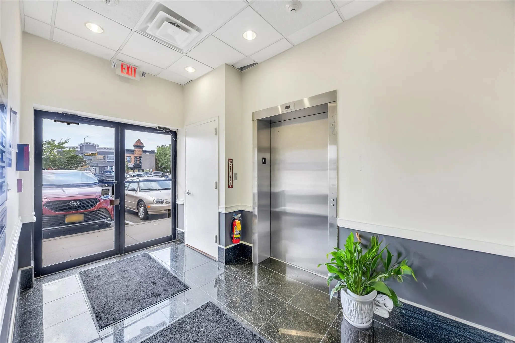 Building lobby with a towering ceiling, a paneled ceiling, and recessed lighting Building lobby with a towering ceiling, a paneled ceiling, and recessed lighting