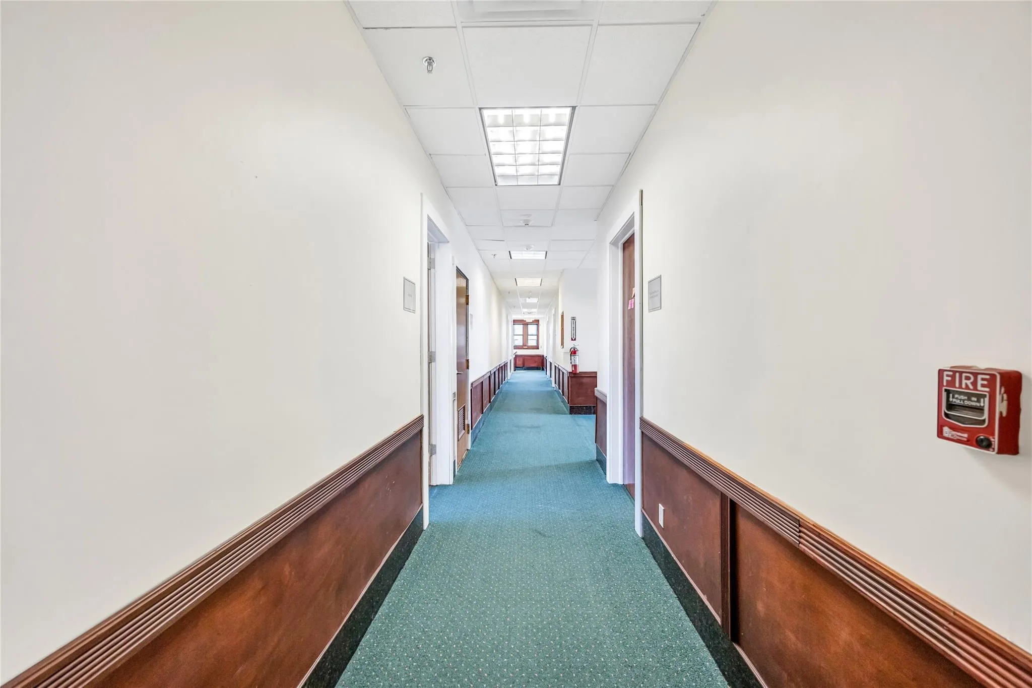 Corridor with a drop ceiling and carpet Corridor with a drop ceiling and carpet