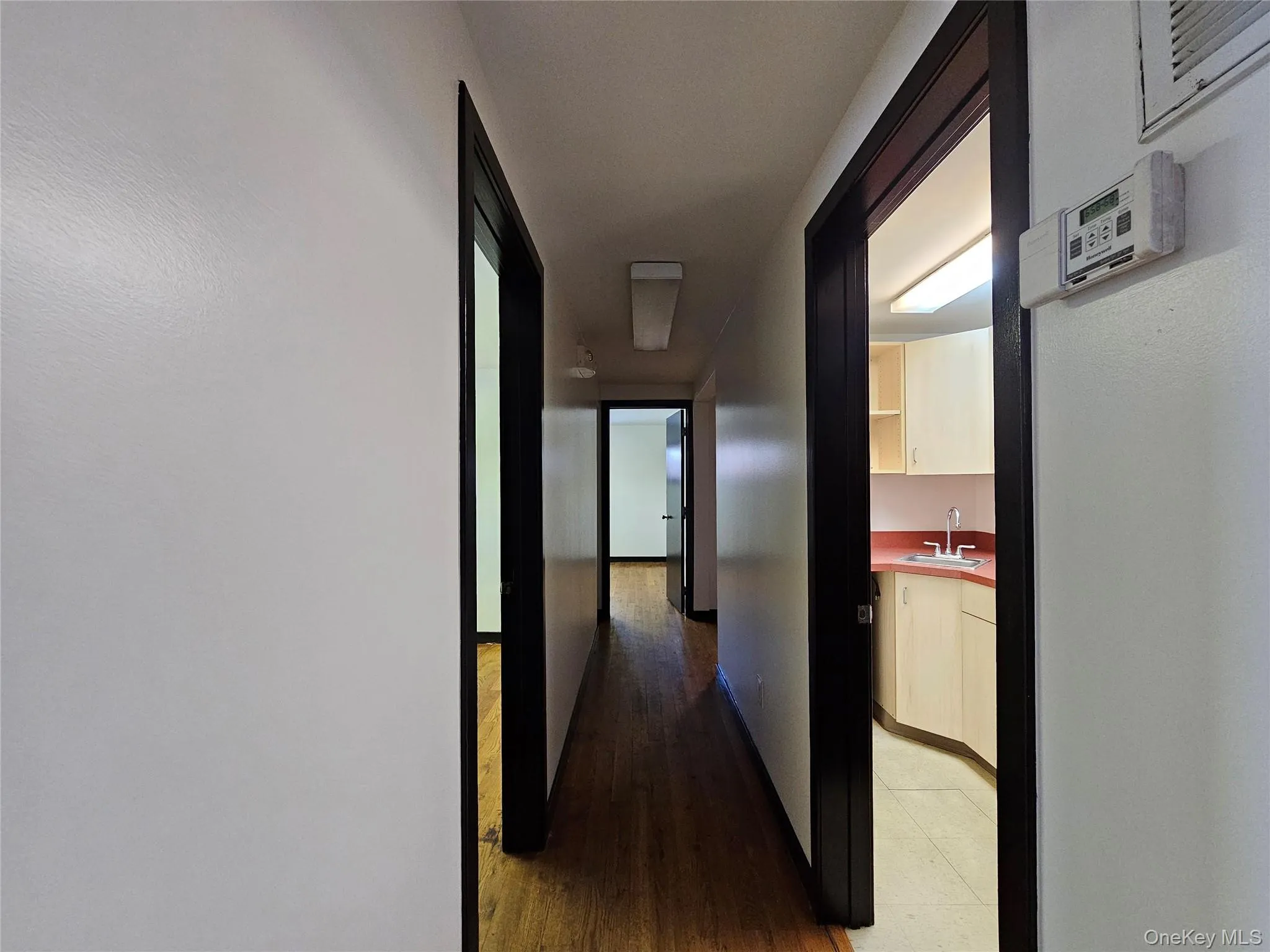 Corridor with a sink and dark wood-style flooring Corridor with a sink and dark wood-style flooring