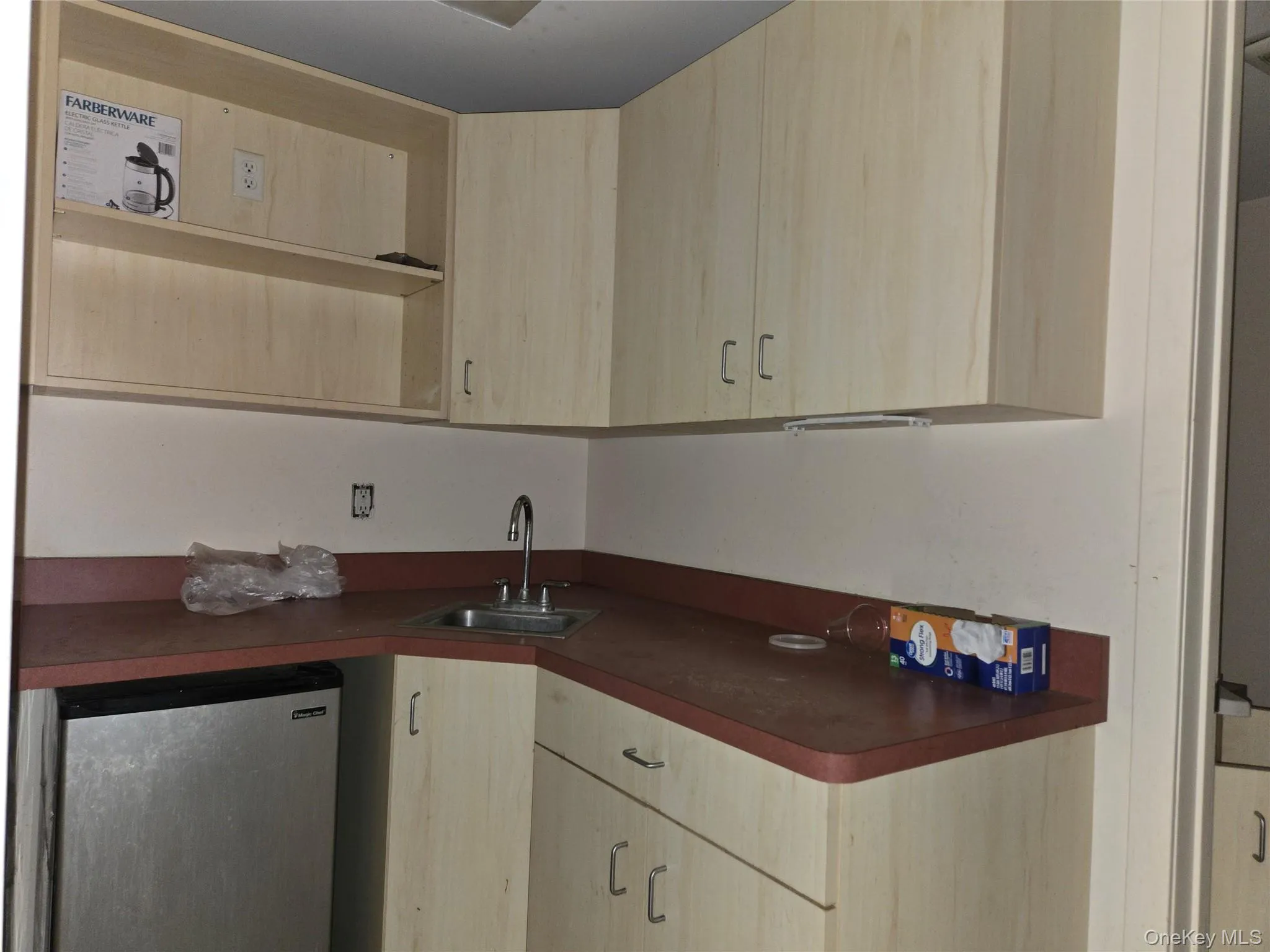 Kitchen with light brown cabinets, dark countertops, and fridge Kitchen with light brown cabinets, dark countertops, and fridge