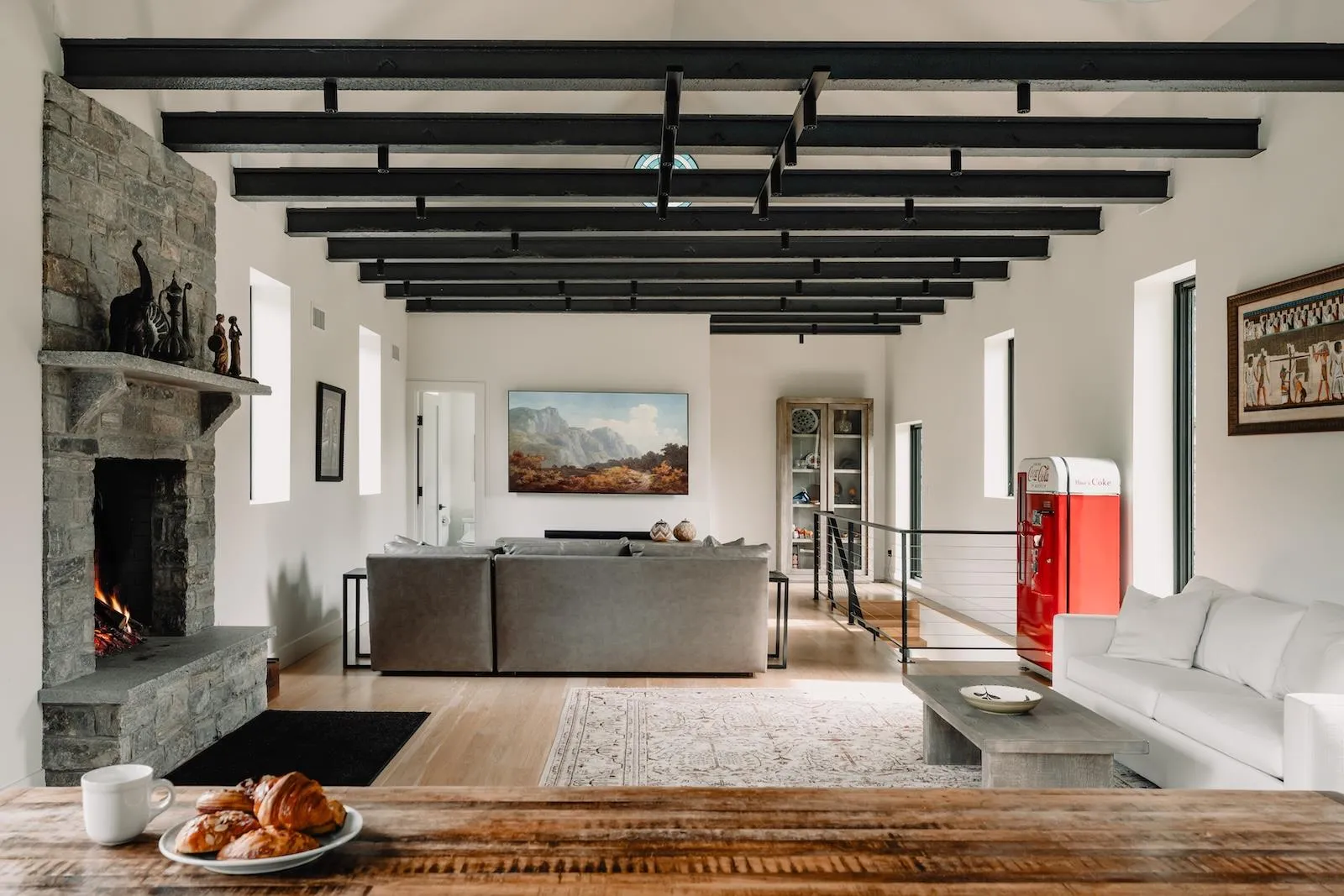 Living room featuring wood finished floors, a fireplace, and beam ceiling Living room featuring wood finished floors, a fireplace, and beam ceiling