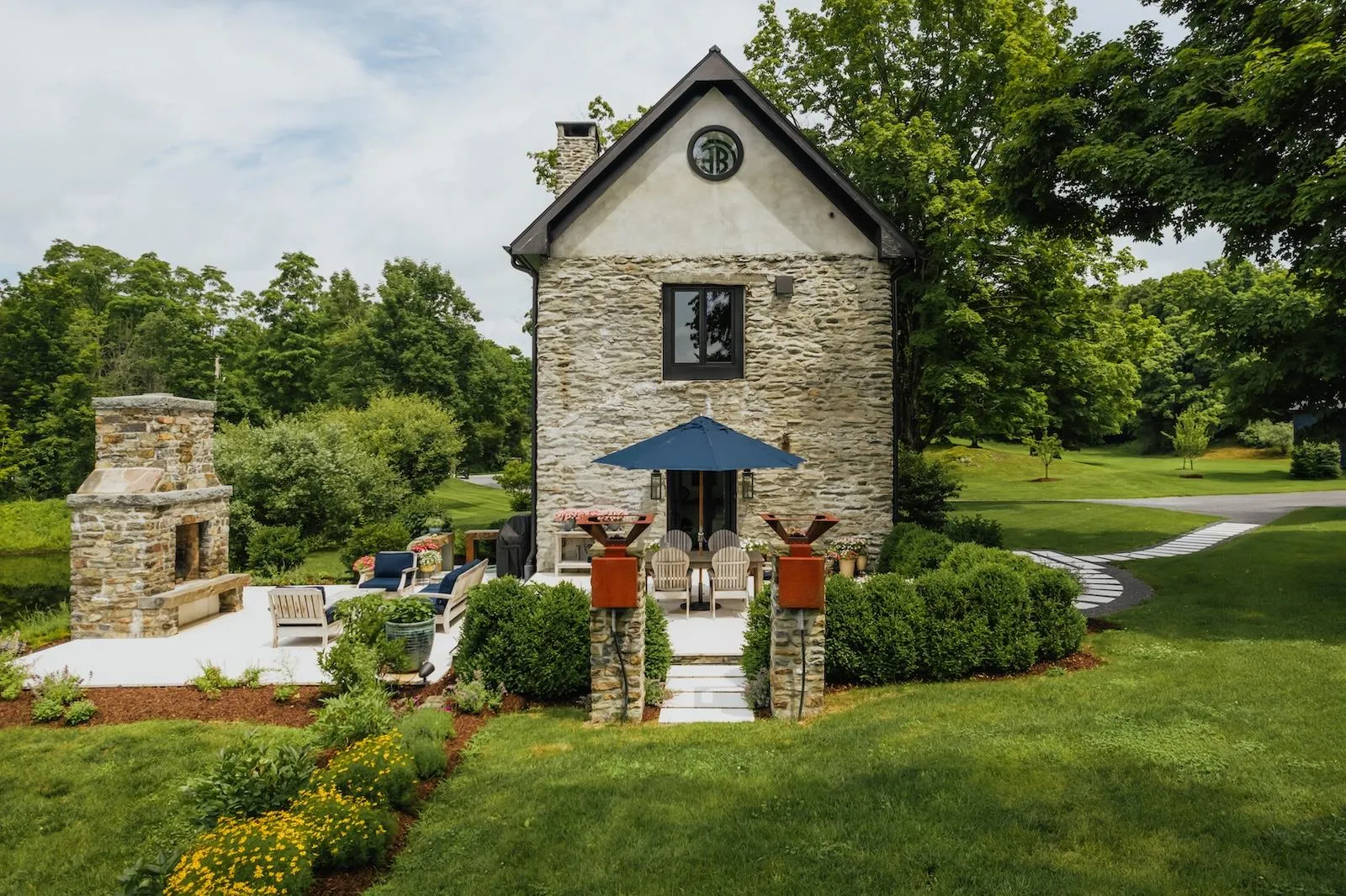 View of outdoor structure with view of wooded area and an outdoor living space with a fireplace View of outdoor structure with view of wooded area and an outdoor living space with a fireplace