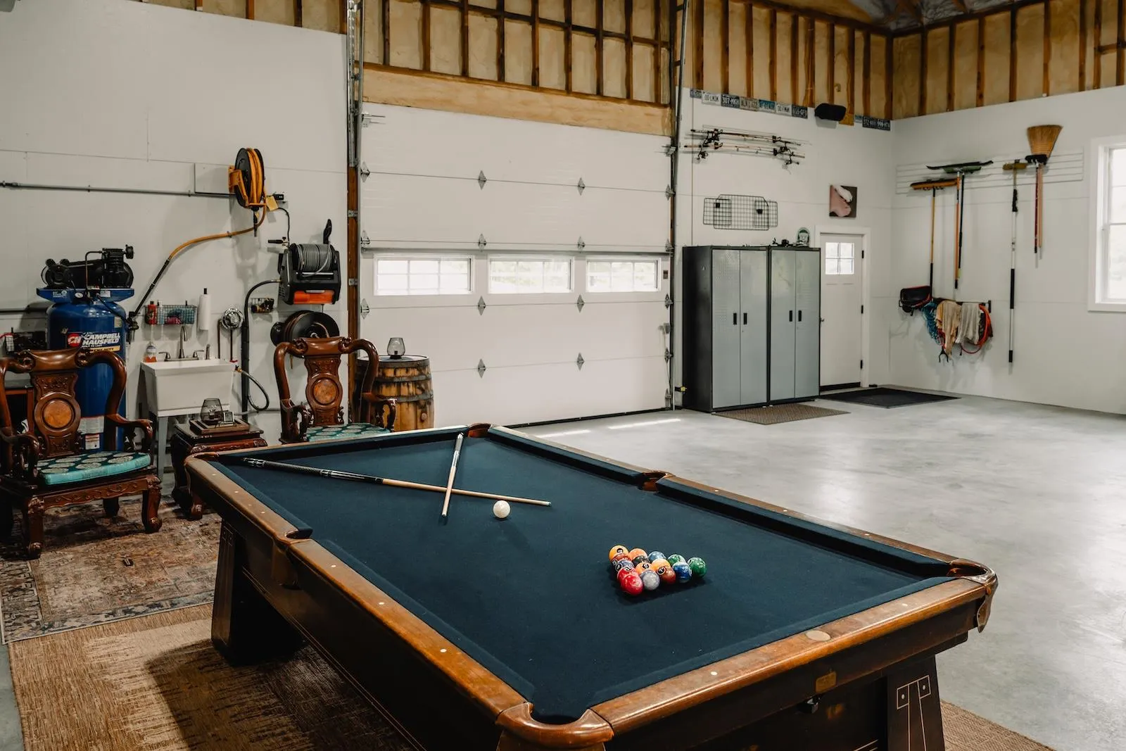 Game room with billiards, concrete floors, and a garage Game room with billiards, concrete floors, and a garage