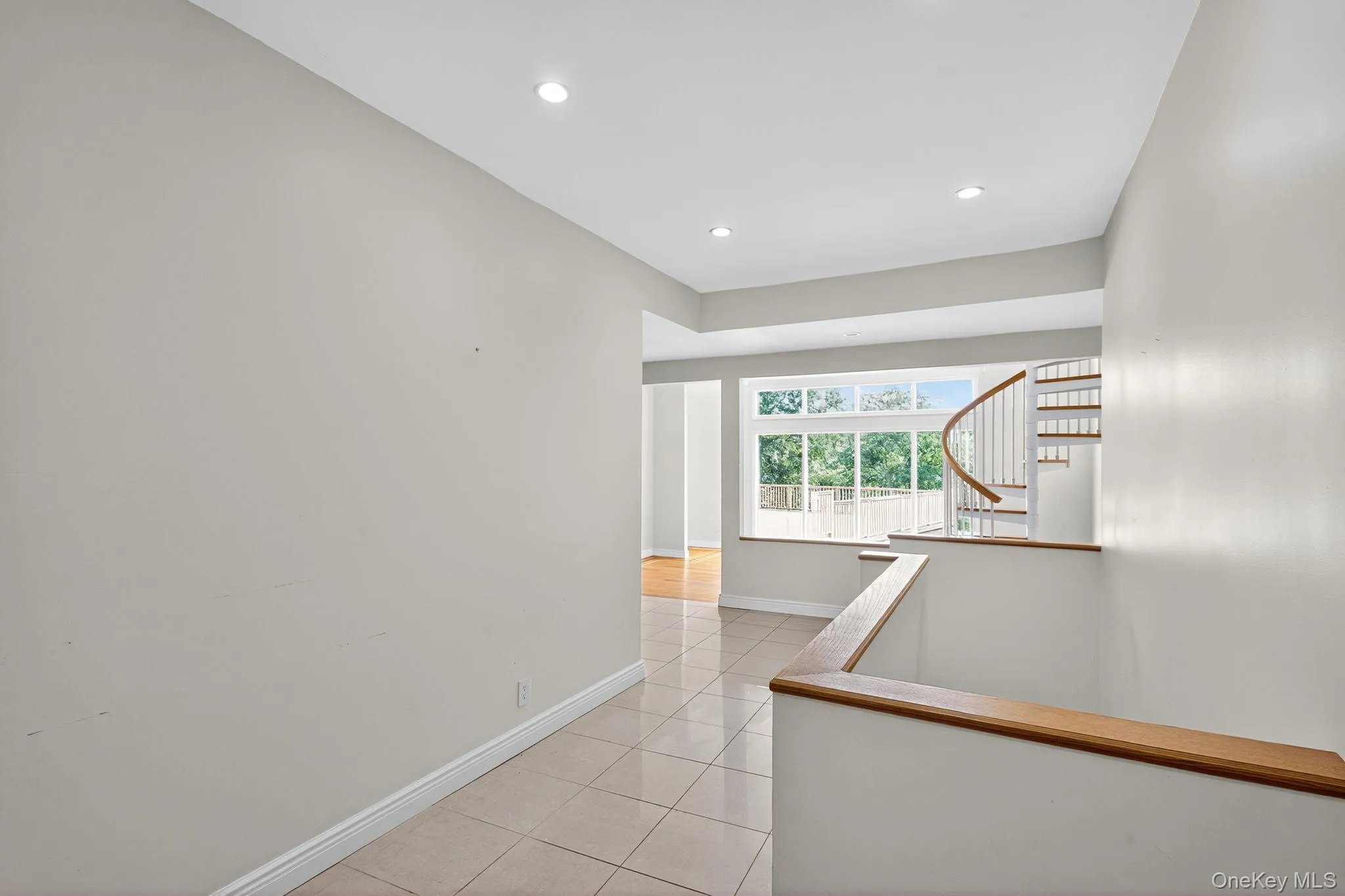 Corridor featuring light tile patterned floors, recessed lighting, and stairs Corridor featuring light tile patterned floors, recessed lighting, and stairs