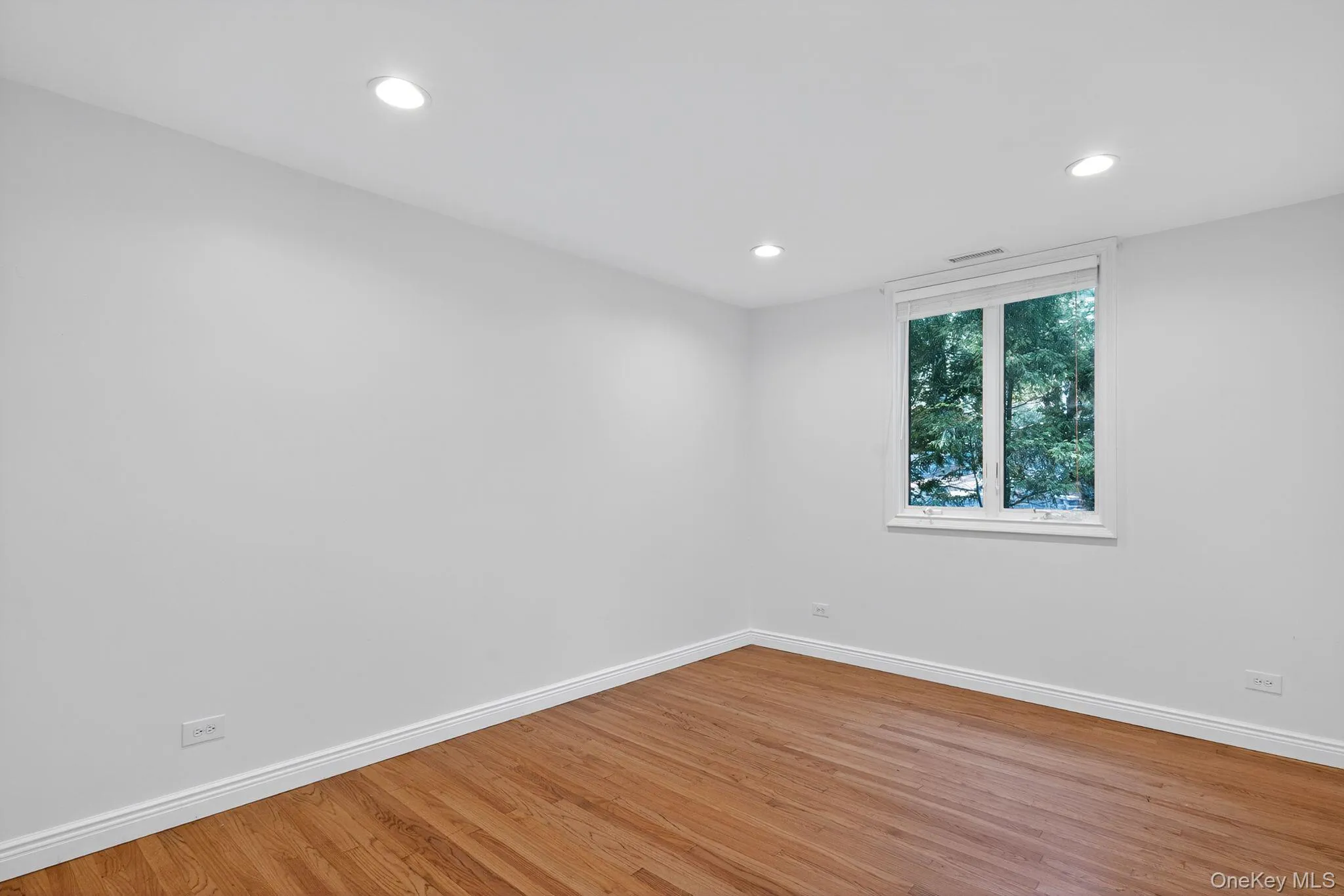 Empty room featuring wood finished floors and recessed lighting Empty room featuring wood finished floors and recessed lighting