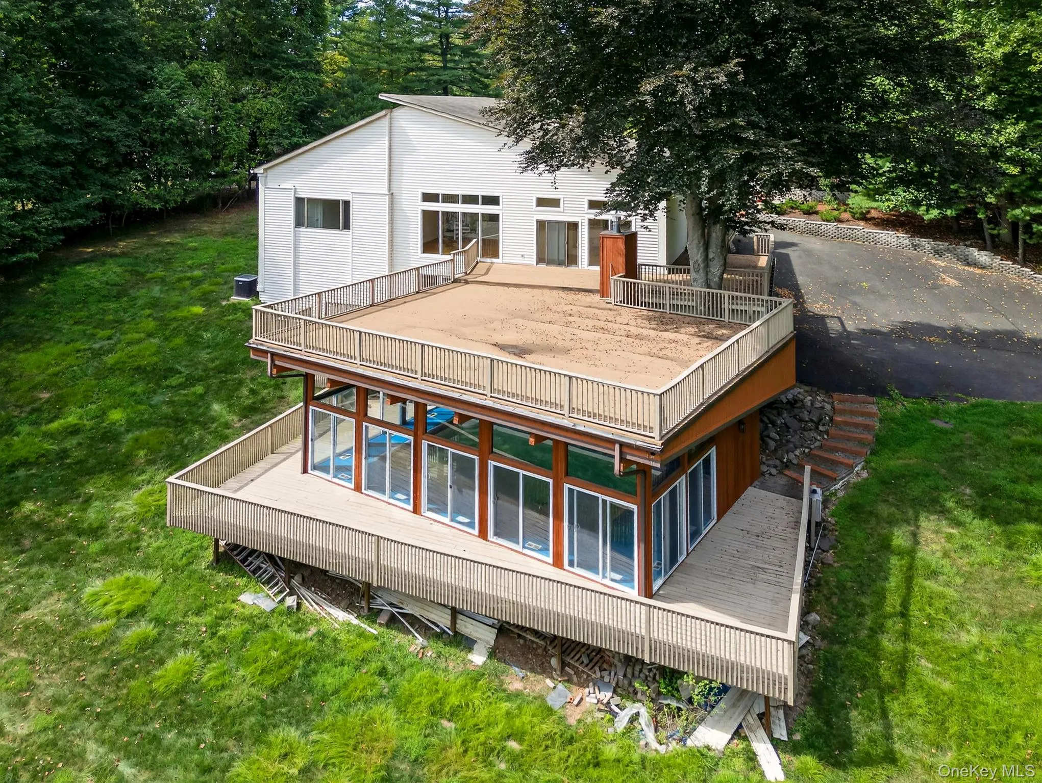 Rear view of property featuring a wooden deck and a lawn Rear view of property featuring a wooden deck and a lawn