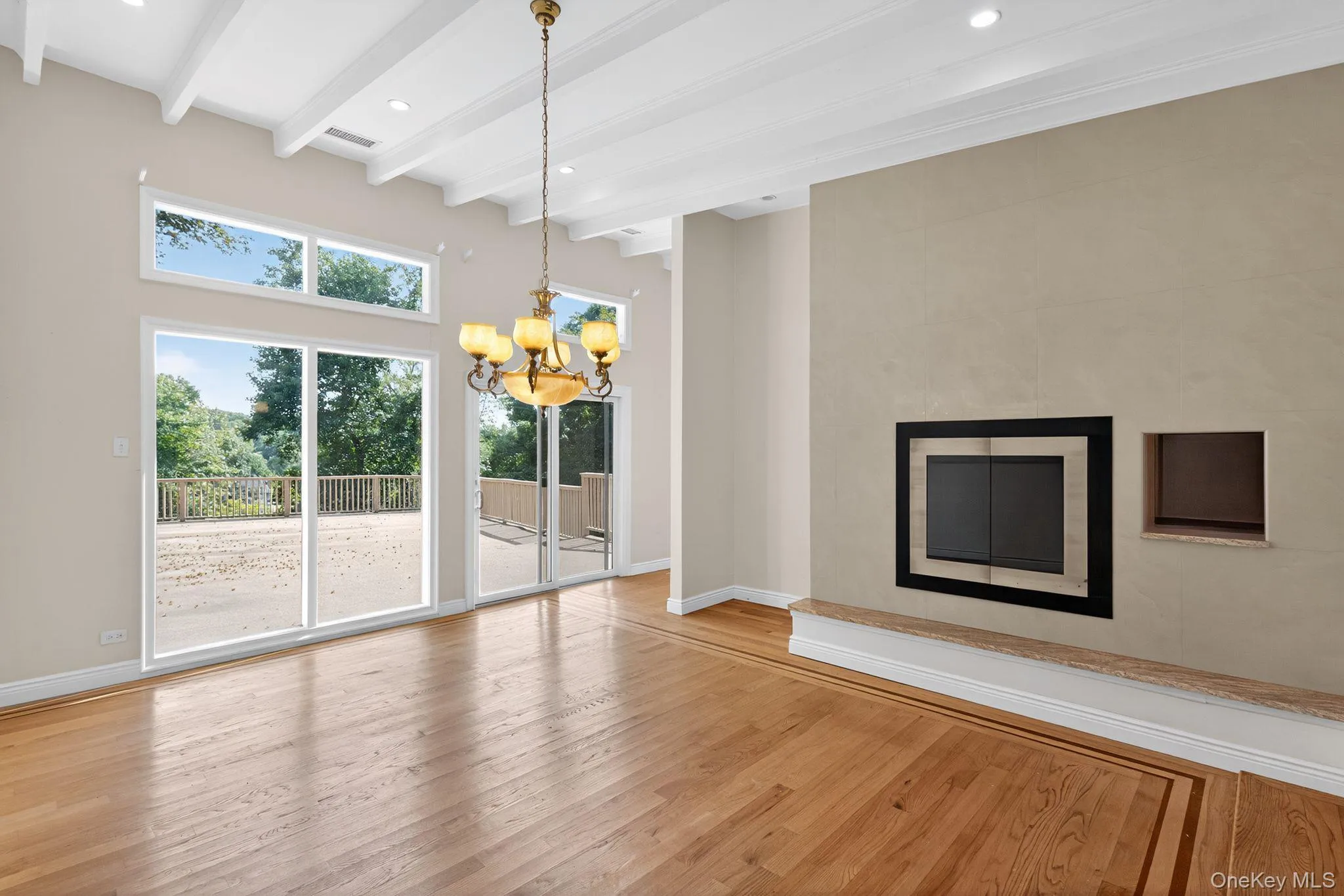 Unfurnished living room featuring beam ceiling, wood finished floors, a chandelier, and recessed lighting Unfurnished living room featuring beam ceiling, wood finished floors, a chandelier, and recessed lighting