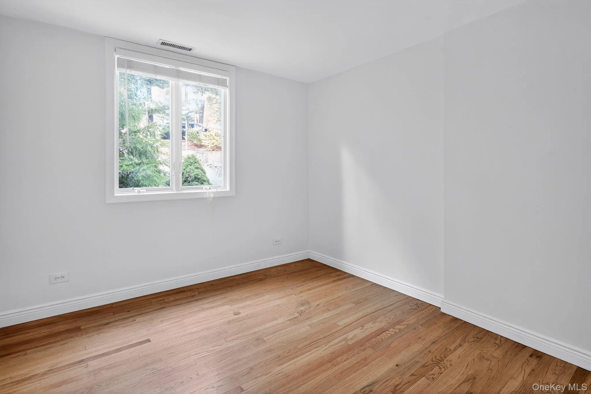 Empty room featuring light wood finished floors and baseboards Empty room featuring light wood finished floors and baseboards