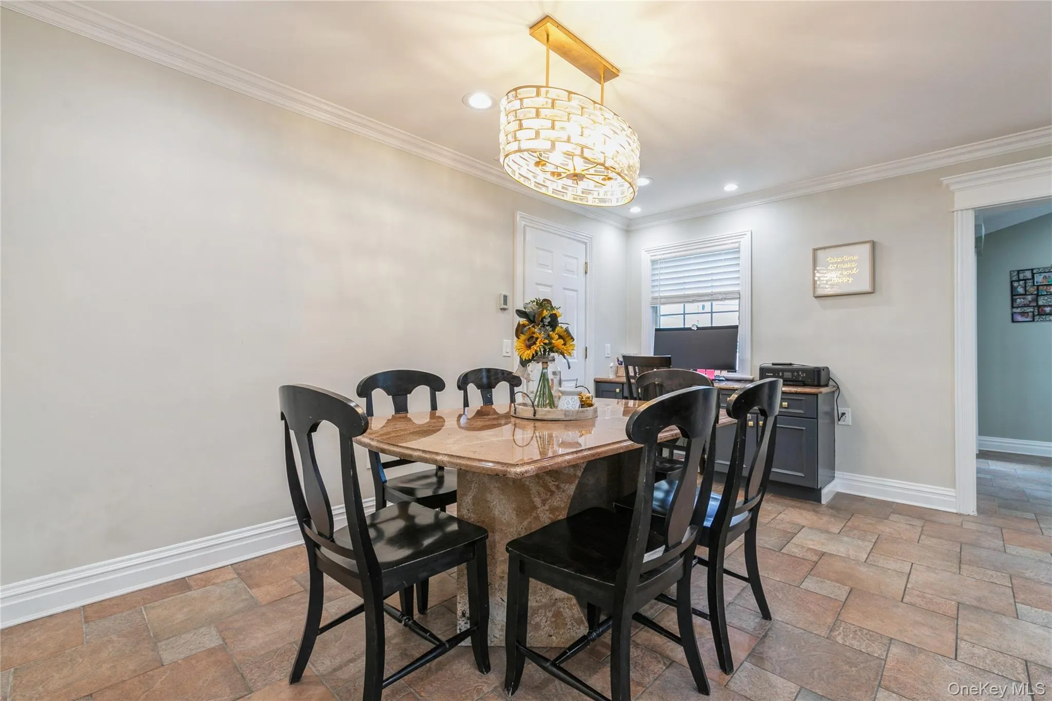 Dining area featuring stone tile flooring, ornamental molding, a chandelier, and recessed lighting Dining area featuring stone tile flooring, ornamental molding, a chandelier, and recessed lighting