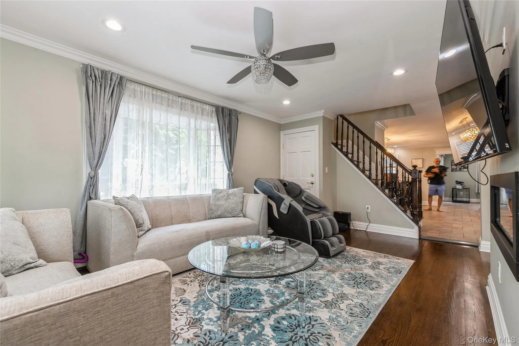 Living room with stairs, ceiling fan, ornamental molding, dark wood finished floors, and recessed lighting Living room with stairs, ceiling fan, ornamental molding, dark wood finished floors, and recessed lighting