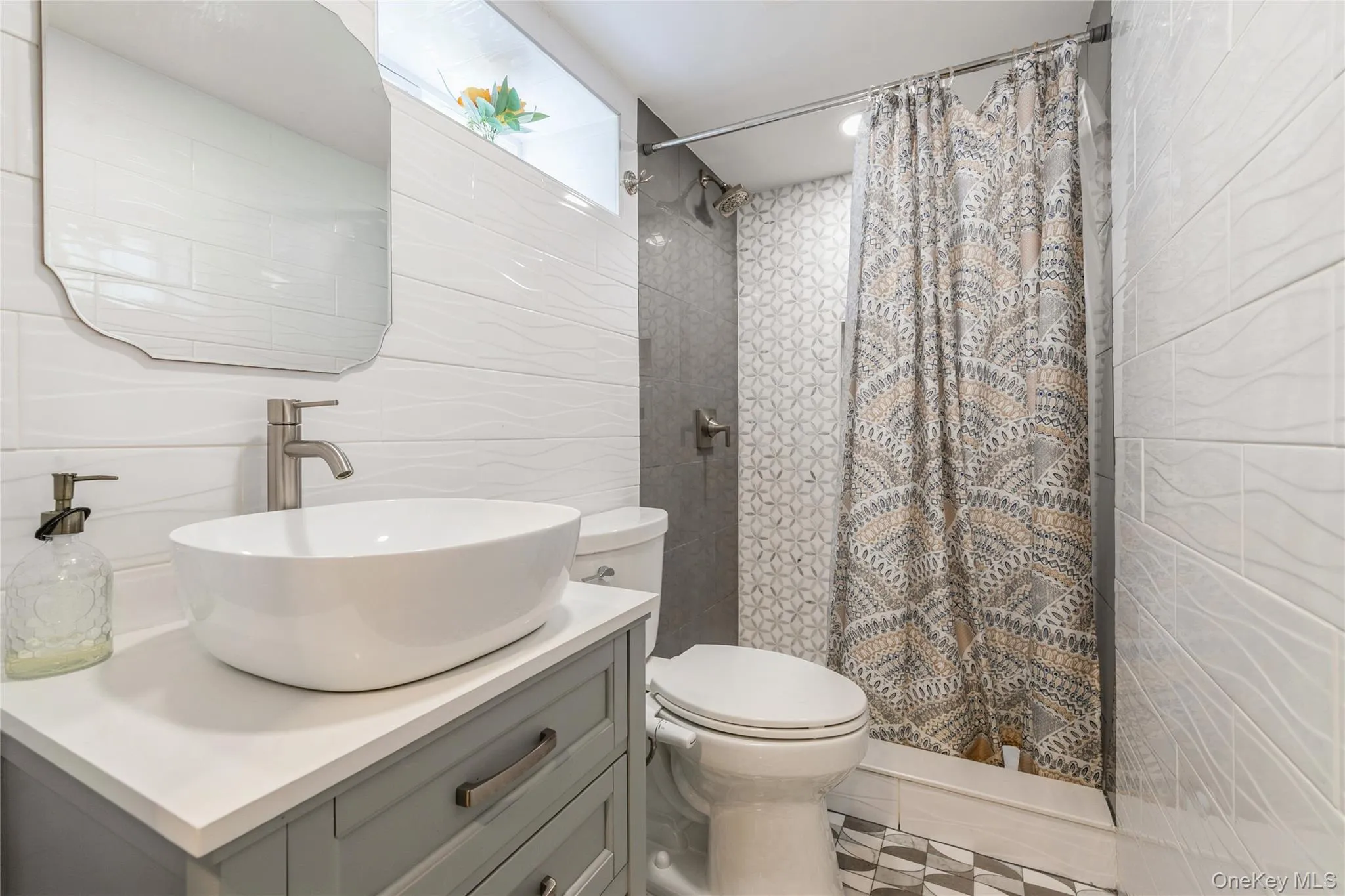 Bathroom featuring tile walls, vanity, and a shower with curtain Bathroom featuring tile walls, vanity, and a shower with curtain