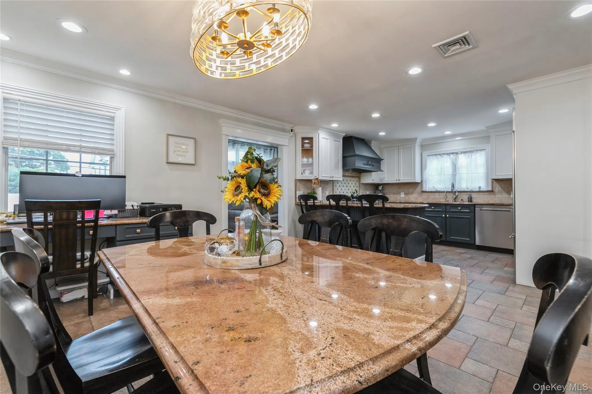 Dining area featuring stone tile flooring, crown molding, a chandelier, and recessed lighting Dining area featuring stone tile flooring, crown molding, a chandelier, and recessed lighting