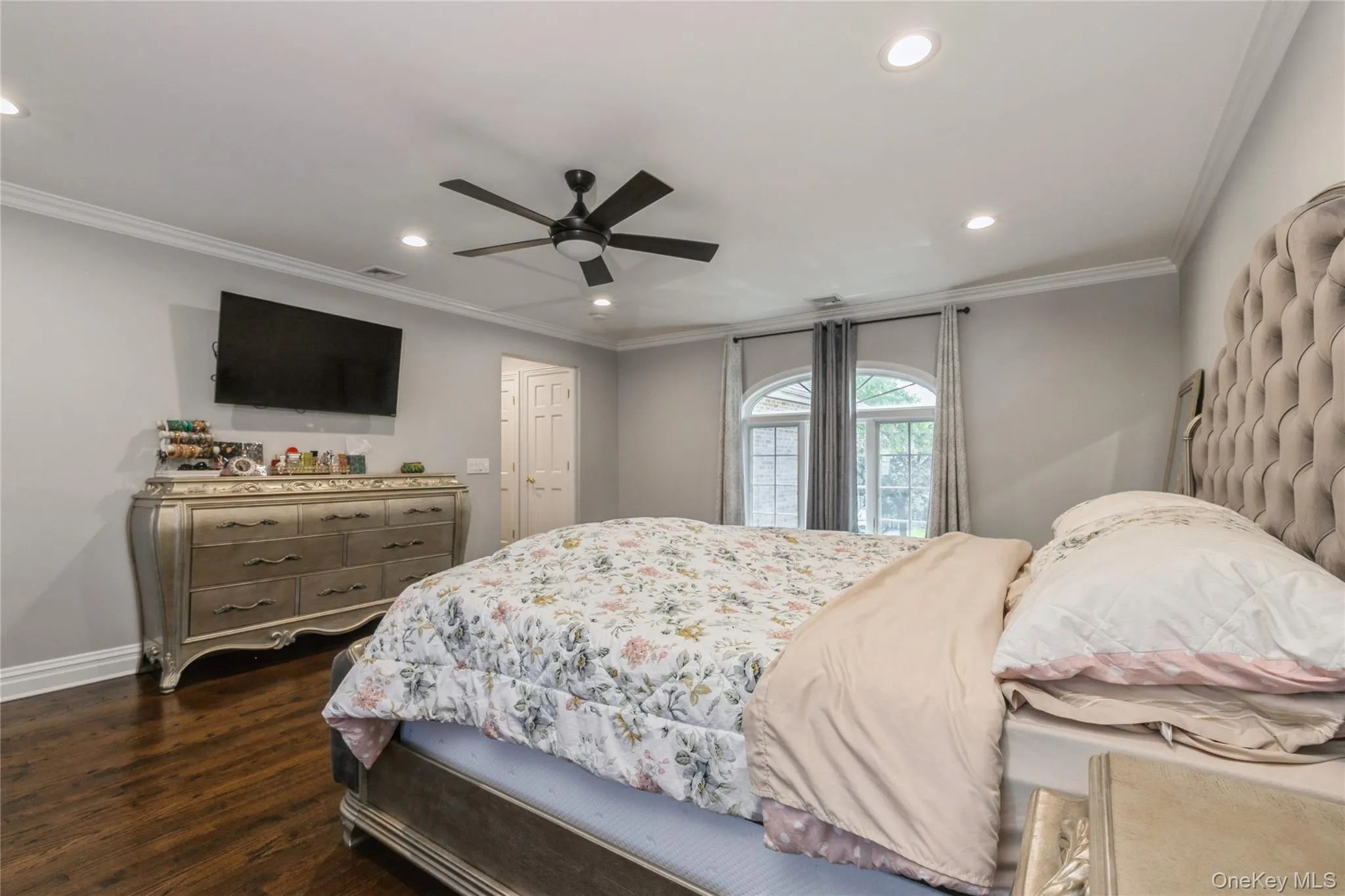 Bedroom with recessed lighting, dark wood-type flooring, ornamental molding, and a ceiling fan Bedroom with recessed lighting, dark wood-type flooring, ornamental molding, and a ceiling fan