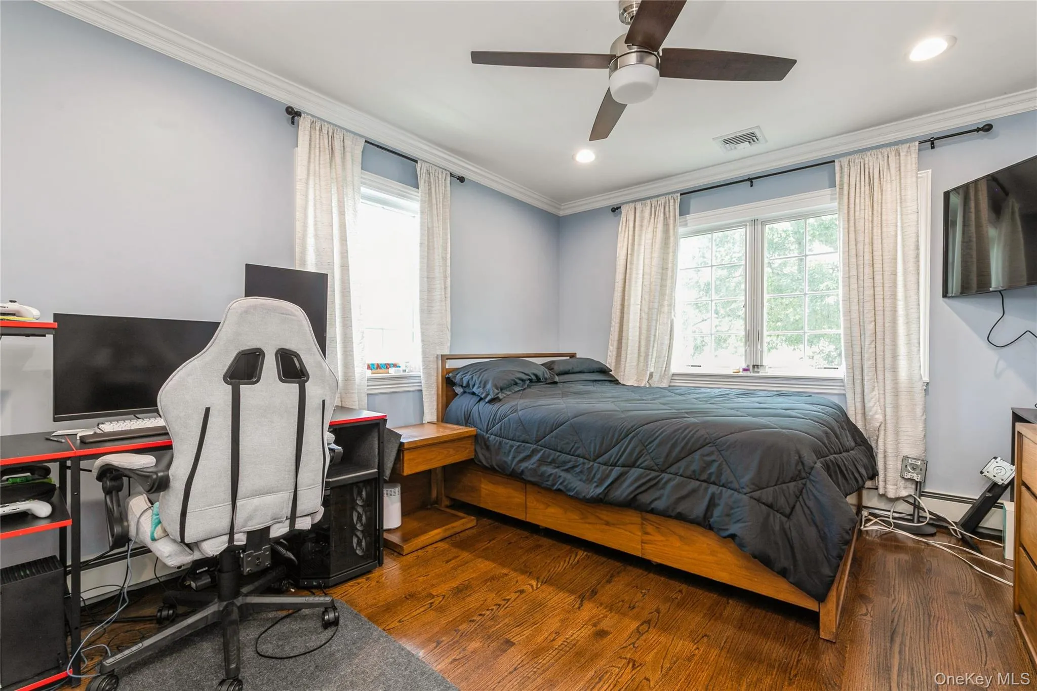 Bedroom featuring wood finished floors, crown molding, recessed lighting, and a ceiling fan Bedroom featuring wood finished floors, crown molding, recessed lighting, and a ceiling fan