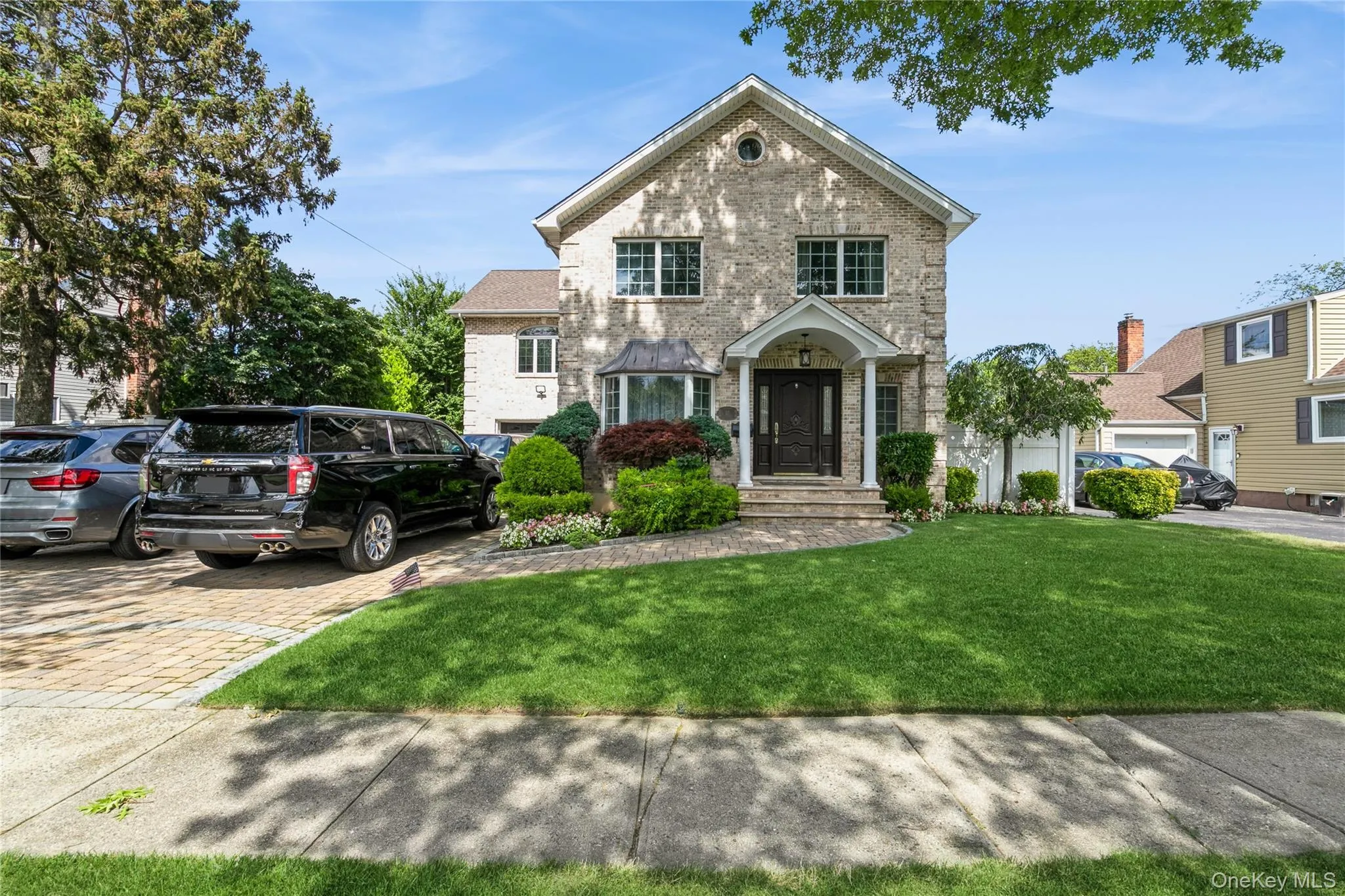 Traditional-style home featuring brick siding and a front yard Traditional-style home featuring brick siding and a front yard