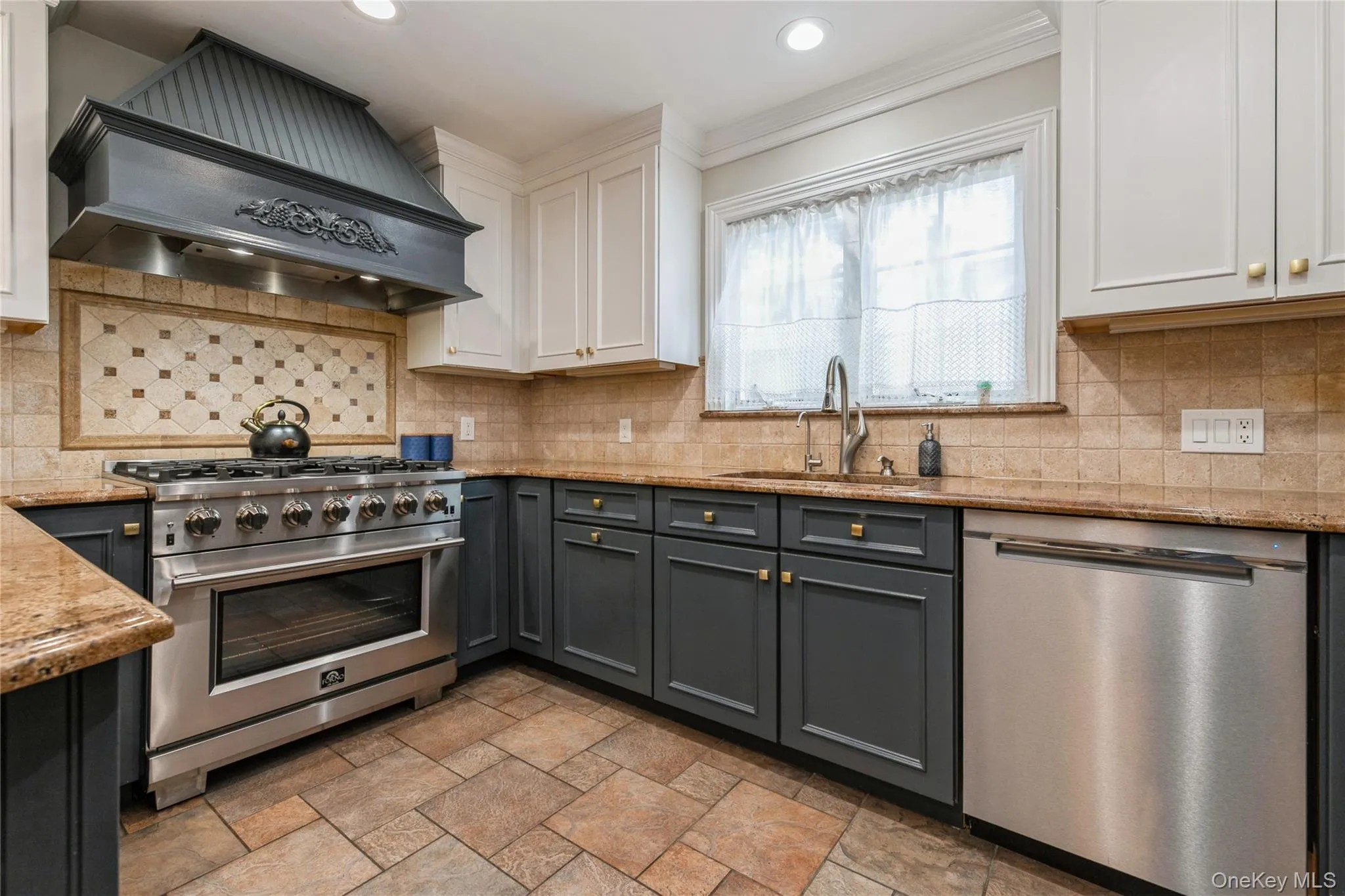 Kitchen featuring stainless steel appliances, premium range hood, white cabinetry, light stone counters, and recessed lighting Kitchen featuring stainless steel appliances, premium range hood, white cabinetry, light stone counters, and recessed lighting