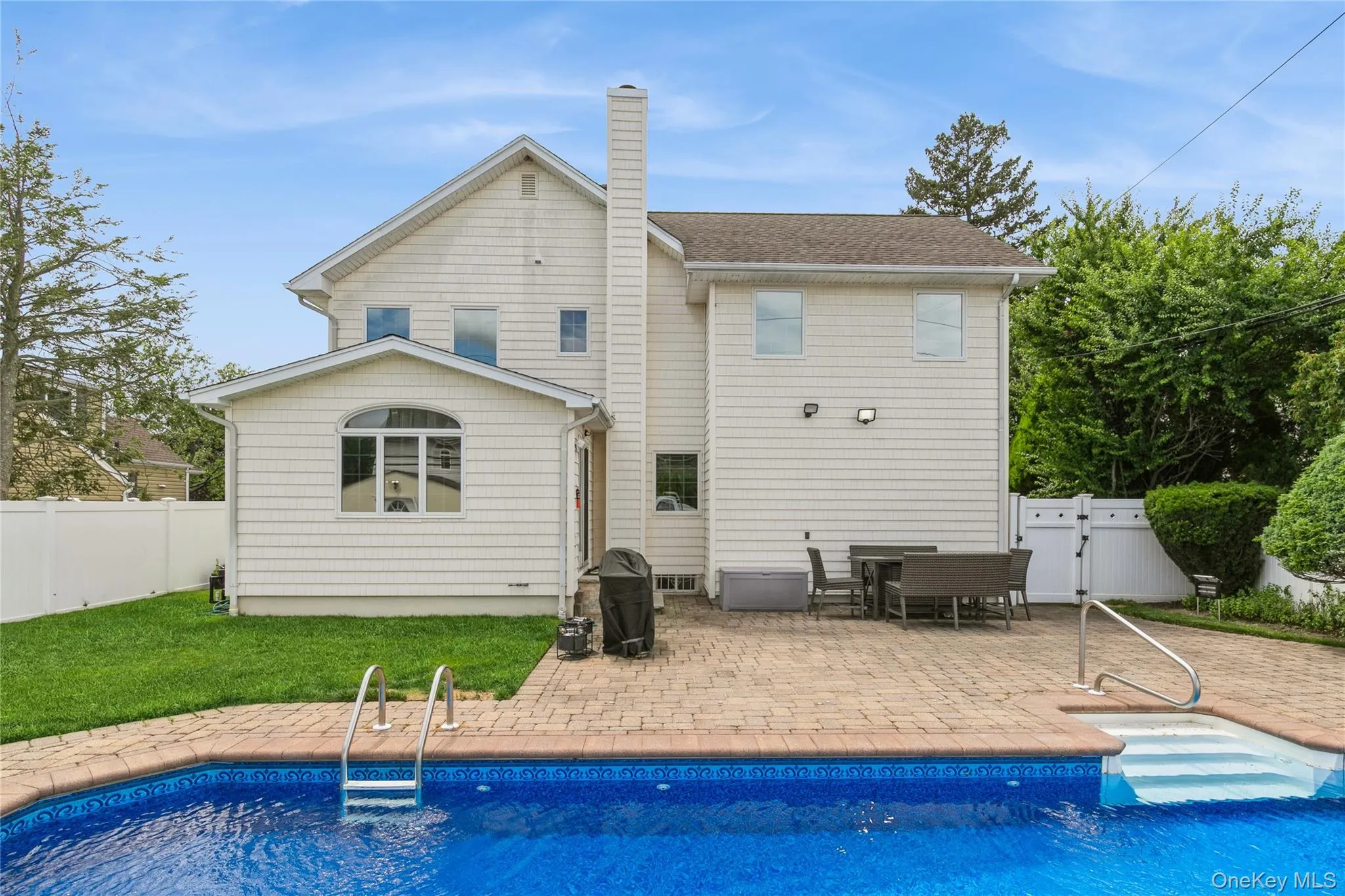 Rear view of property featuring a patio area, a gate, a chimney, and a fenced backyard Rear view of property featuring a patio area, a gate, a chimney, and a fenced backyard