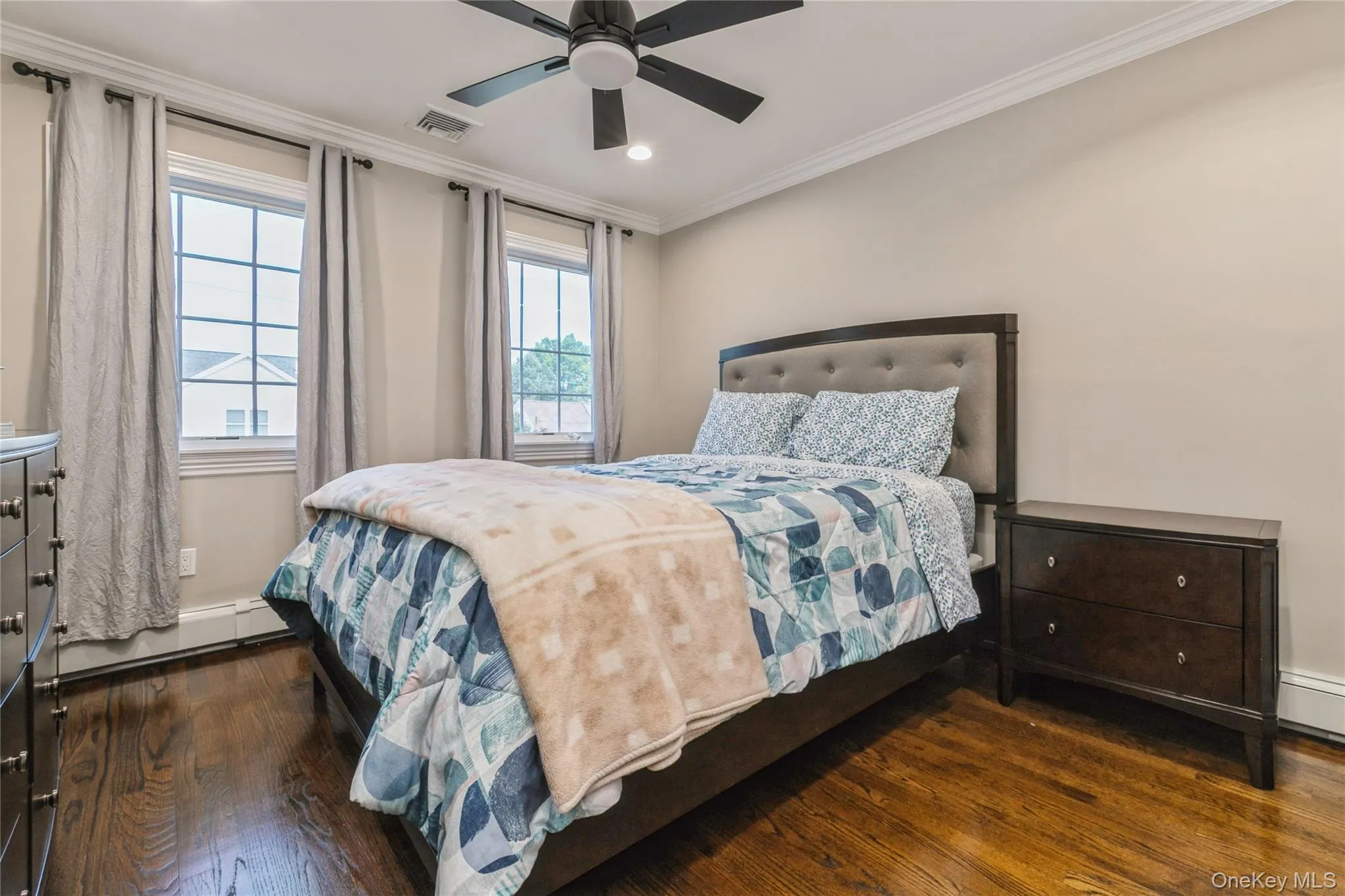 Bedroom with wood finished floors, crown molding, a baseboard radiator, recessed lighting, and a ceiling fan Bedroom with wood finished floors, crown molding, a baseboard radiator, recessed lighting, and a ceiling fan