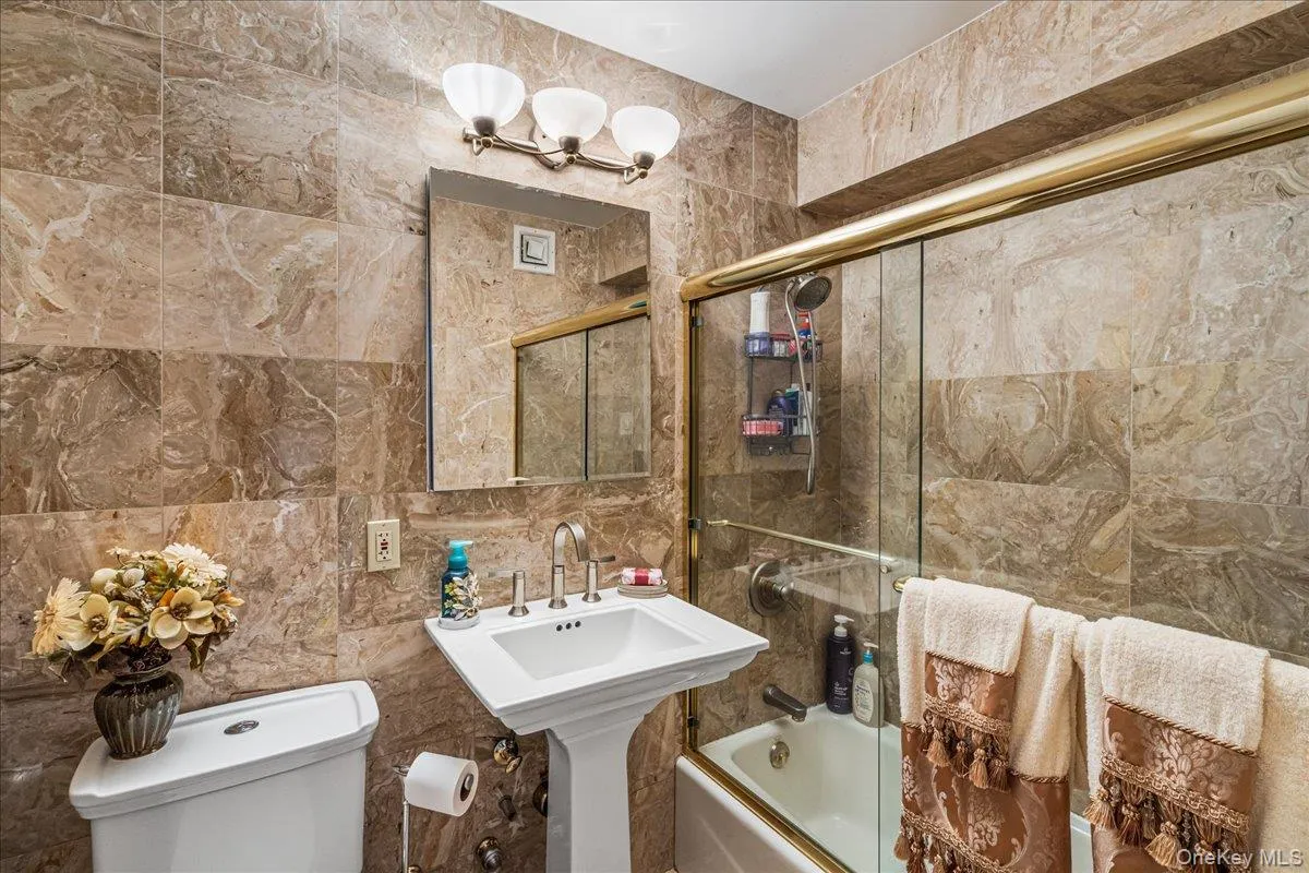 Bathroom with tile walls and shower / bath combination with glass door Bathroom with tile walls and shower / bath combination with glass door