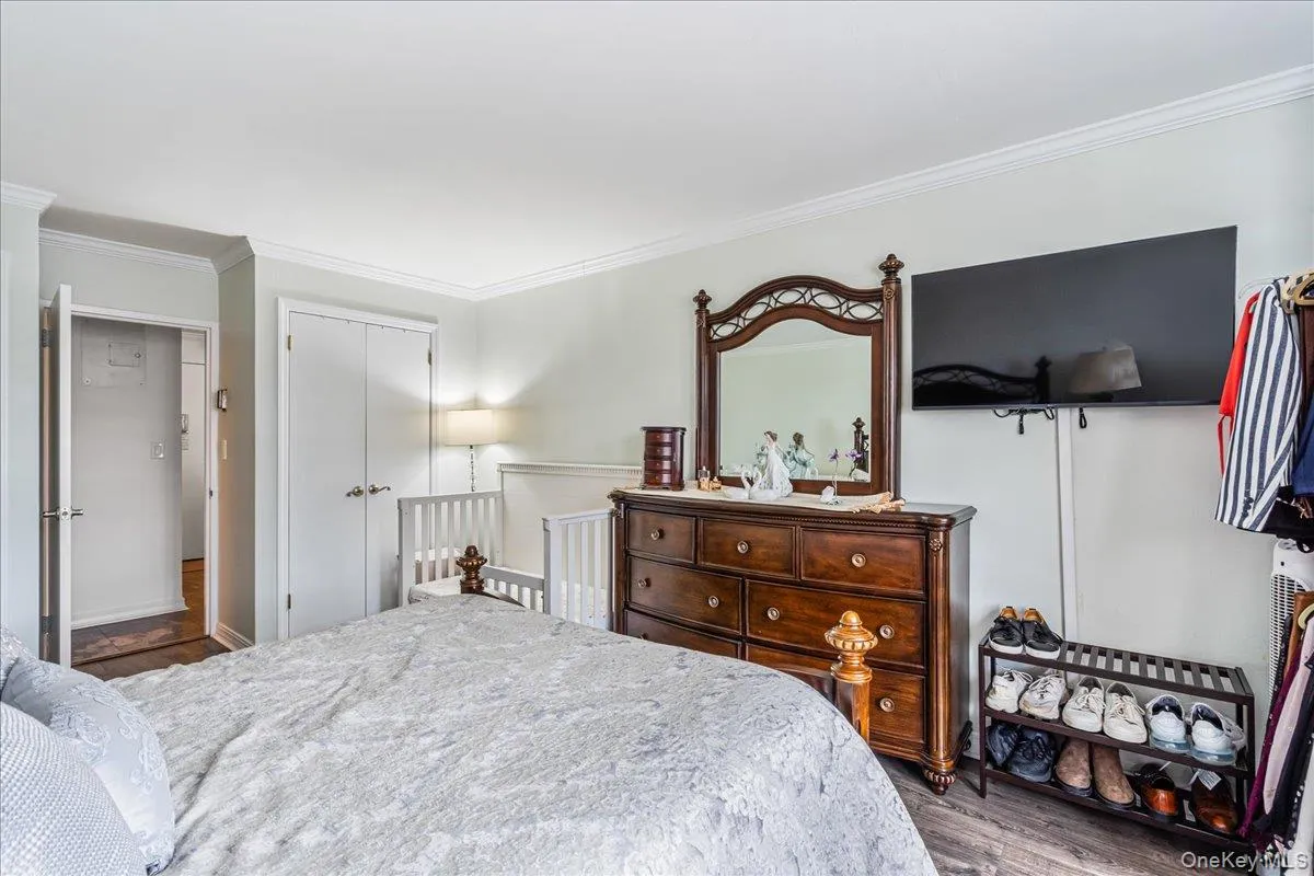Bedroom with crown molding and wood finished floors Bedroom with crown molding and wood finished floors