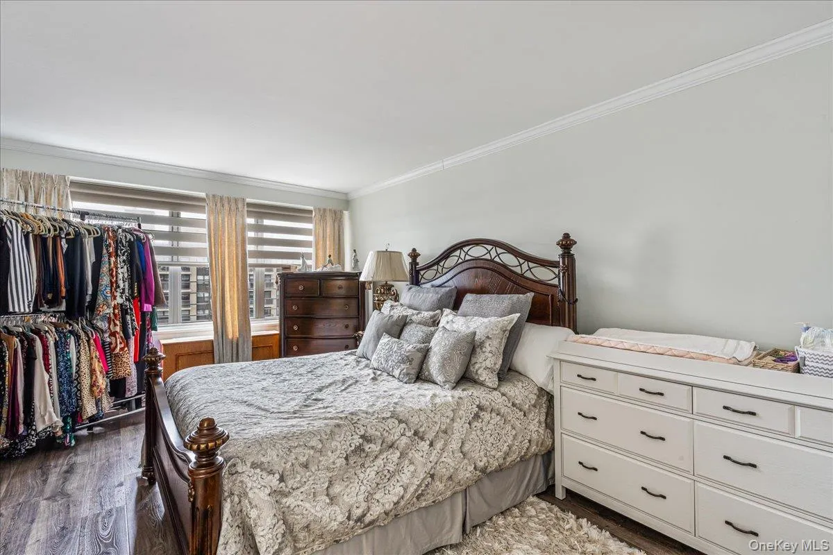 Bedroom featuring crown molding and dark wood finished floors Bedroom featuring crown molding and dark wood finished floors