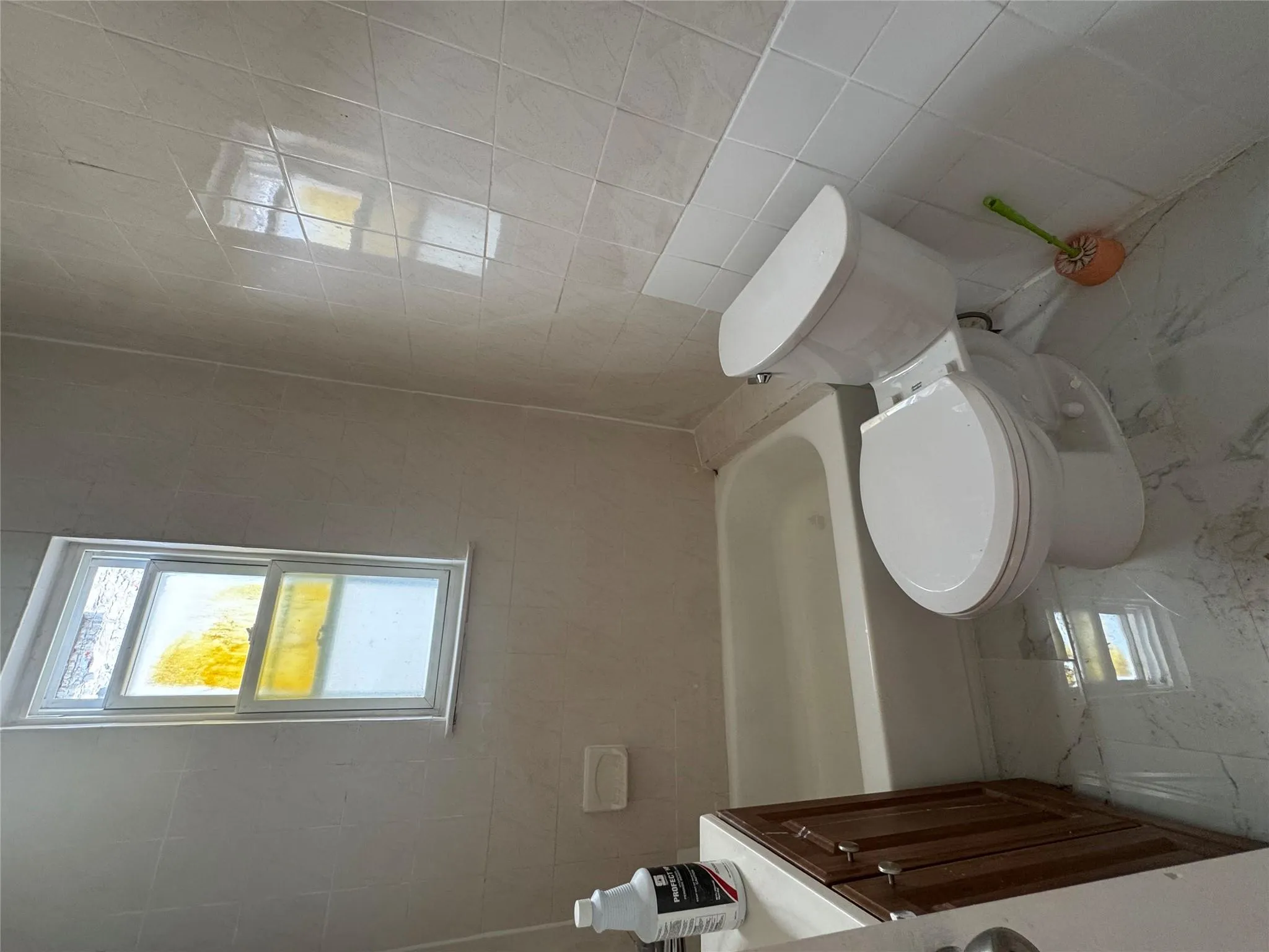 Bathroom with plenty of natural light, tile walls, marble look tile flooring, and vanity Bathroom with plenty of natural light, tile walls, marble look tile flooring, and vanity