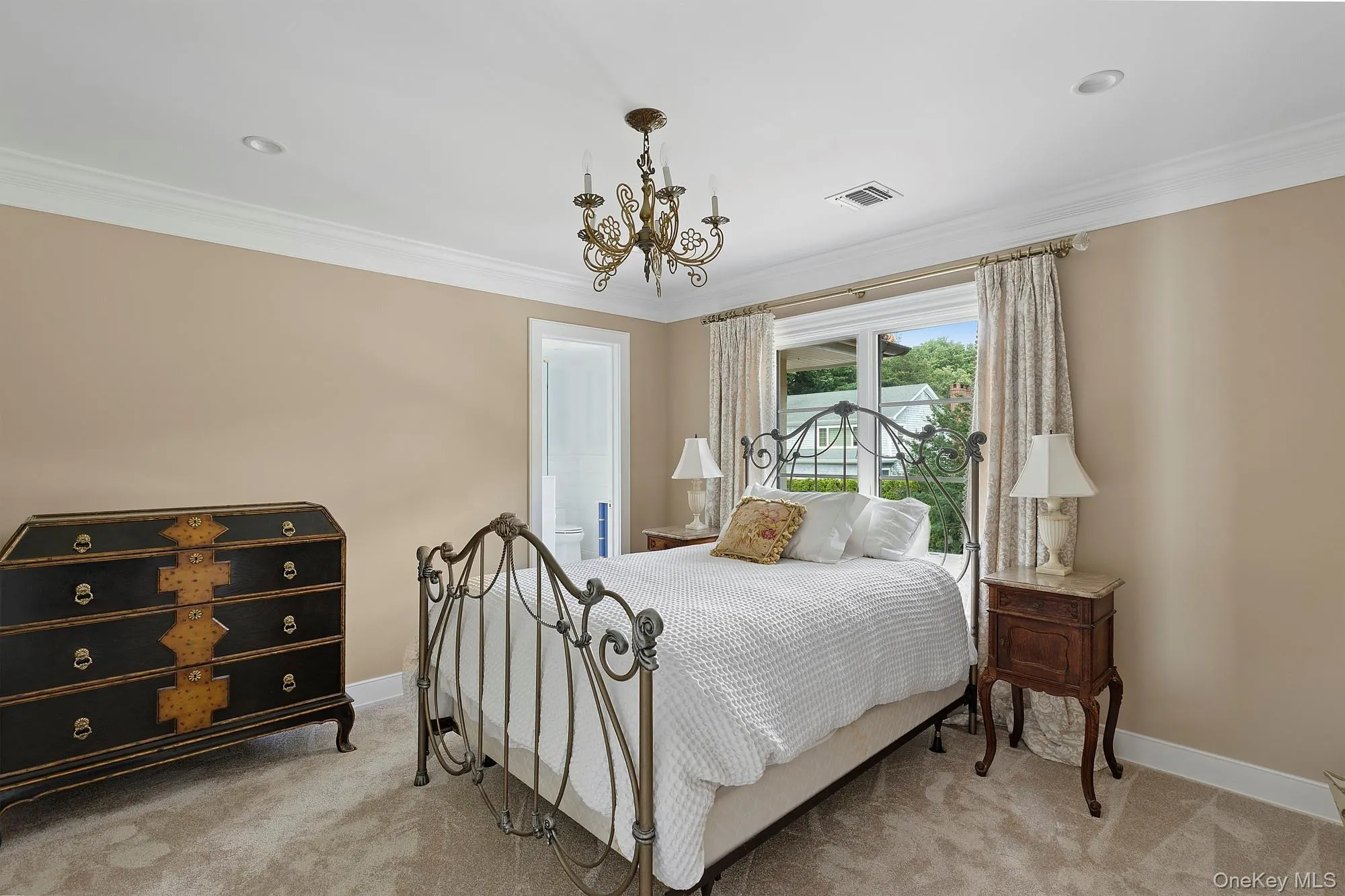 Carpeted bedroom with crown molding and a chandelier Carpeted bedroom with crown molding and a chandelier