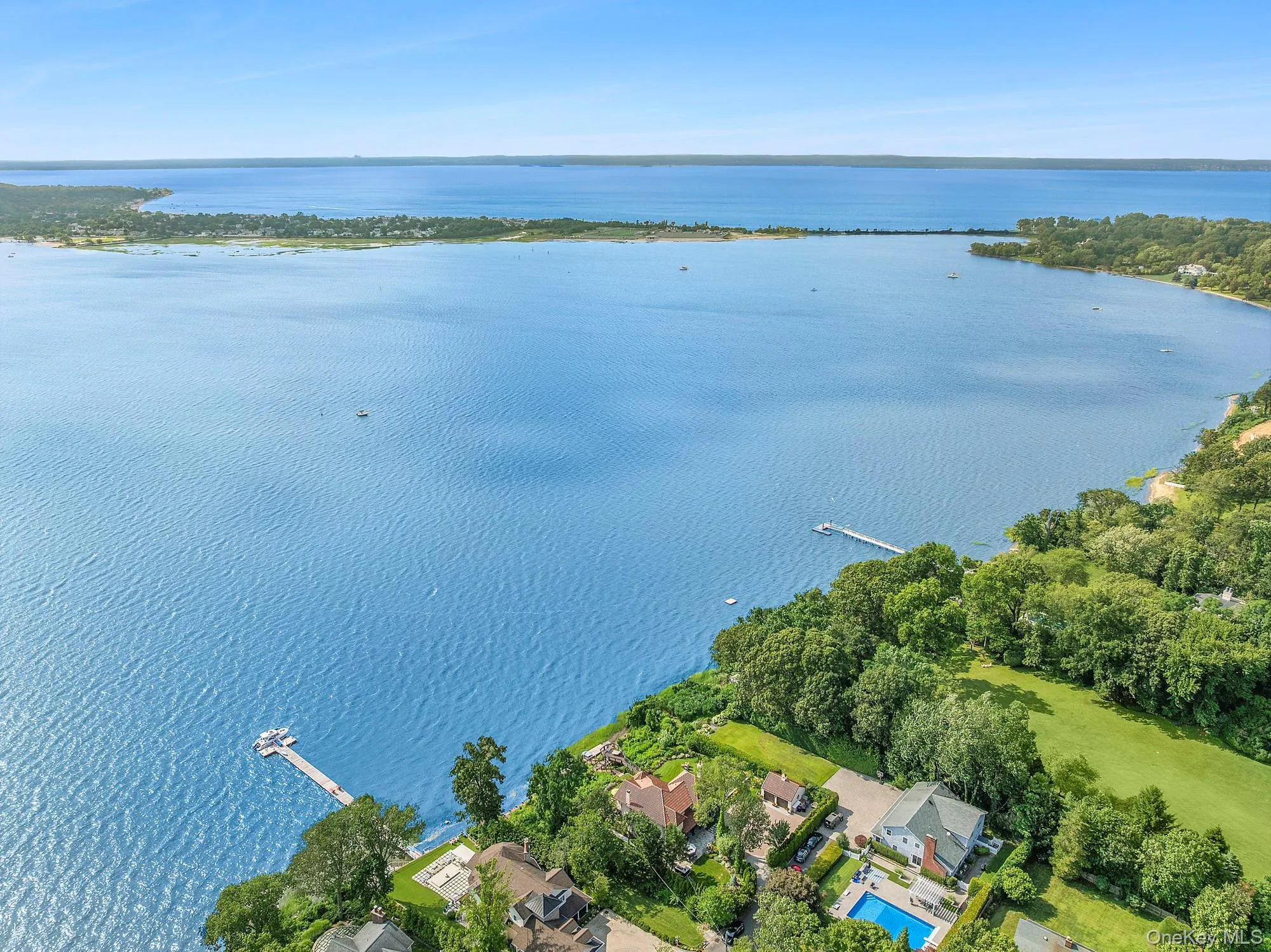 Aerial view of property's location featuring a large body of water and nearby suburban area Aerial view of property's location featuring a large body of water and nearby suburban area