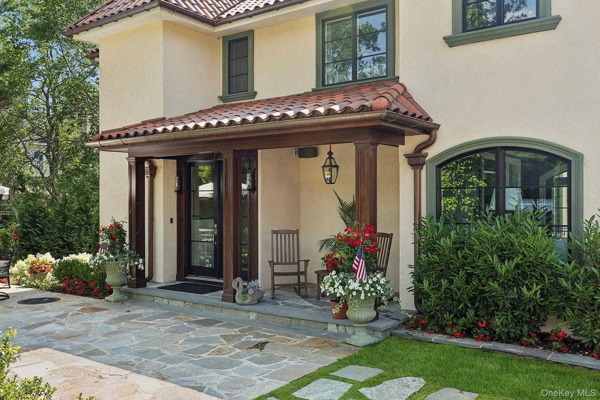 Property entrance featuring covered porch, stucco siding, and a tiled roof Property entrance featuring covered porch, stucco siding, and a tiled roof