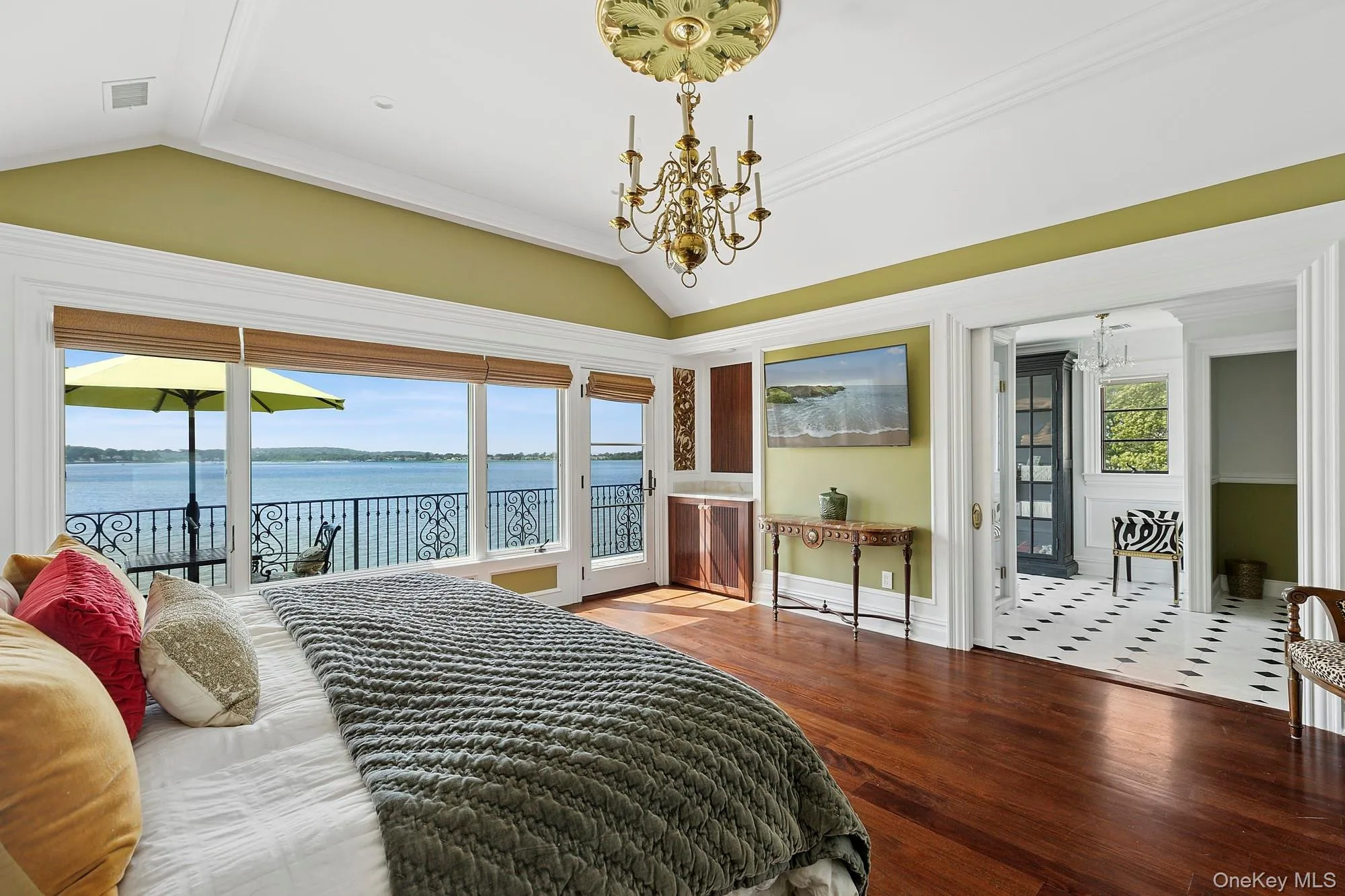 Bedroom with a chandelier, access to outside, lofted ceiling, crown molding, and wood finished floors Bedroom with a chandelier, access to outside, lofted ceiling, crown molding, and wood finished floors