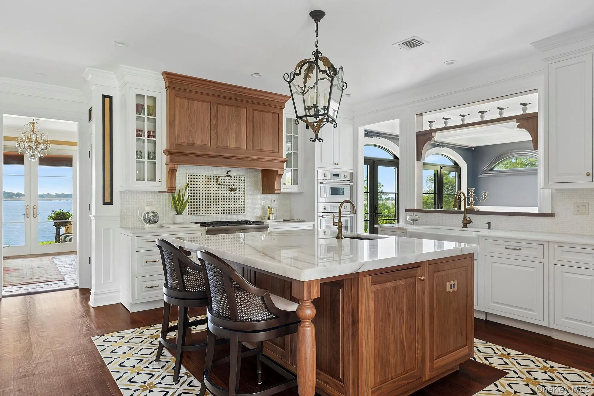 Kitchen featuring a chandelier, tasteful backsplash, brown cabinetry, french doors, and crown molding Kitchen featuring a chandelier, tasteful backsplash, brown cabinetry, french doors, and crown molding